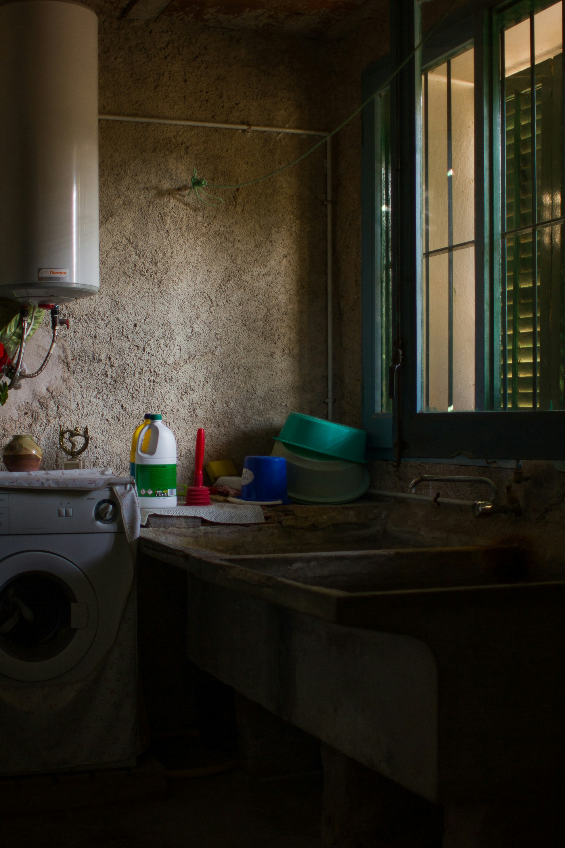 An empty household kitchen with sunlight peeking through a window