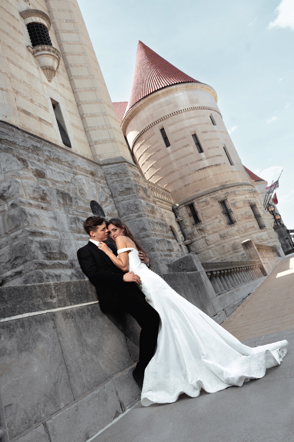 A couple embraces lovingly on a wooden dock.