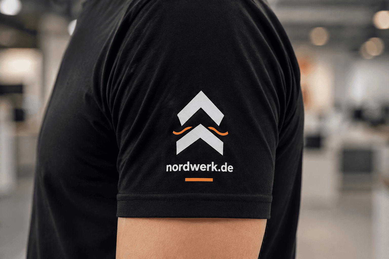 NORDWERK Logo und Webadresse auf schwarzem T-Shirt Ärmel