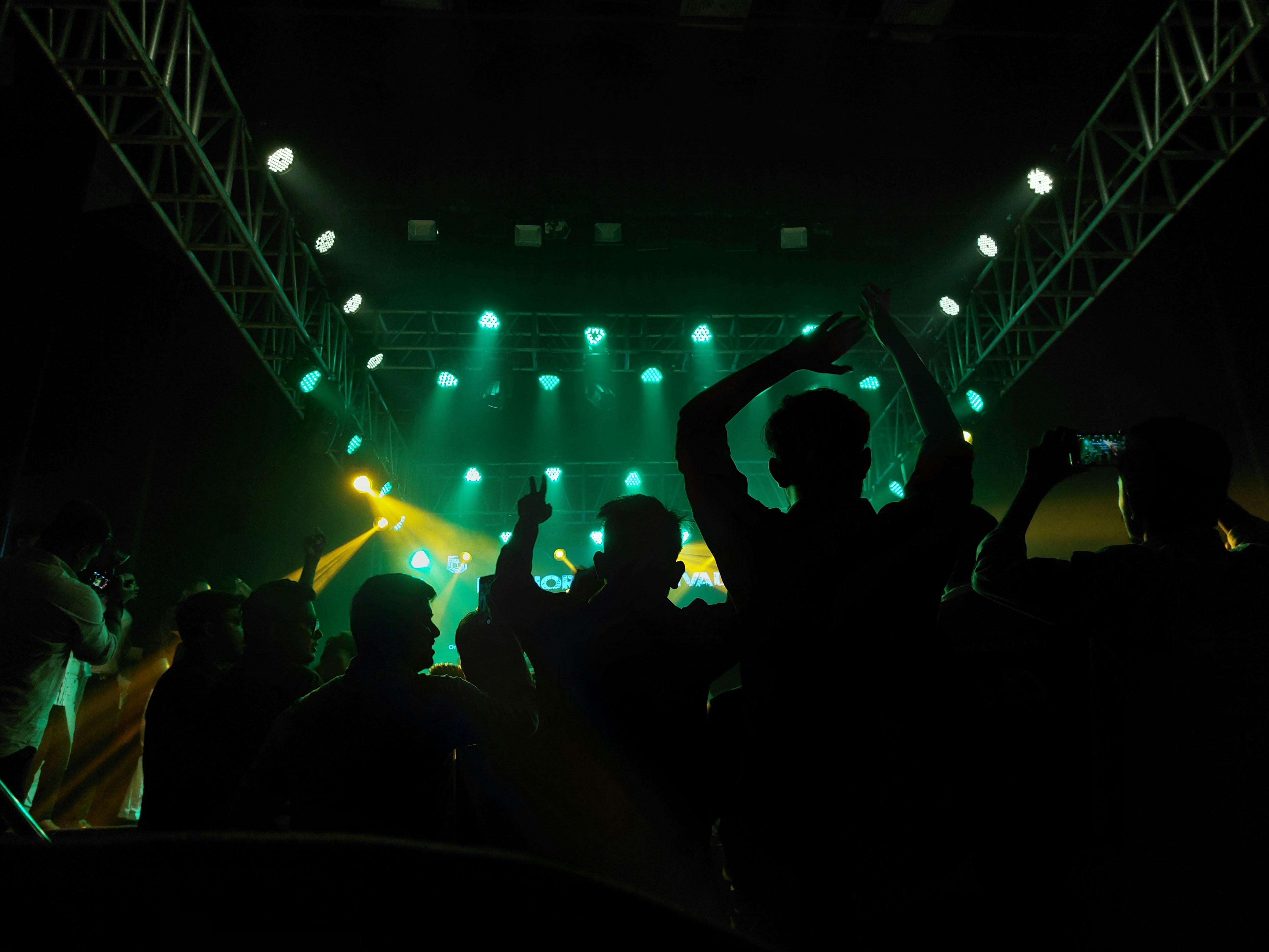 A performance venue with neon lights and a crowd cheering. Photo by Toushif Alam on Unsplash