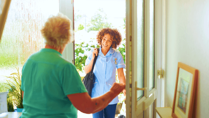 Care worker arriving at door to visit elderly person at home.