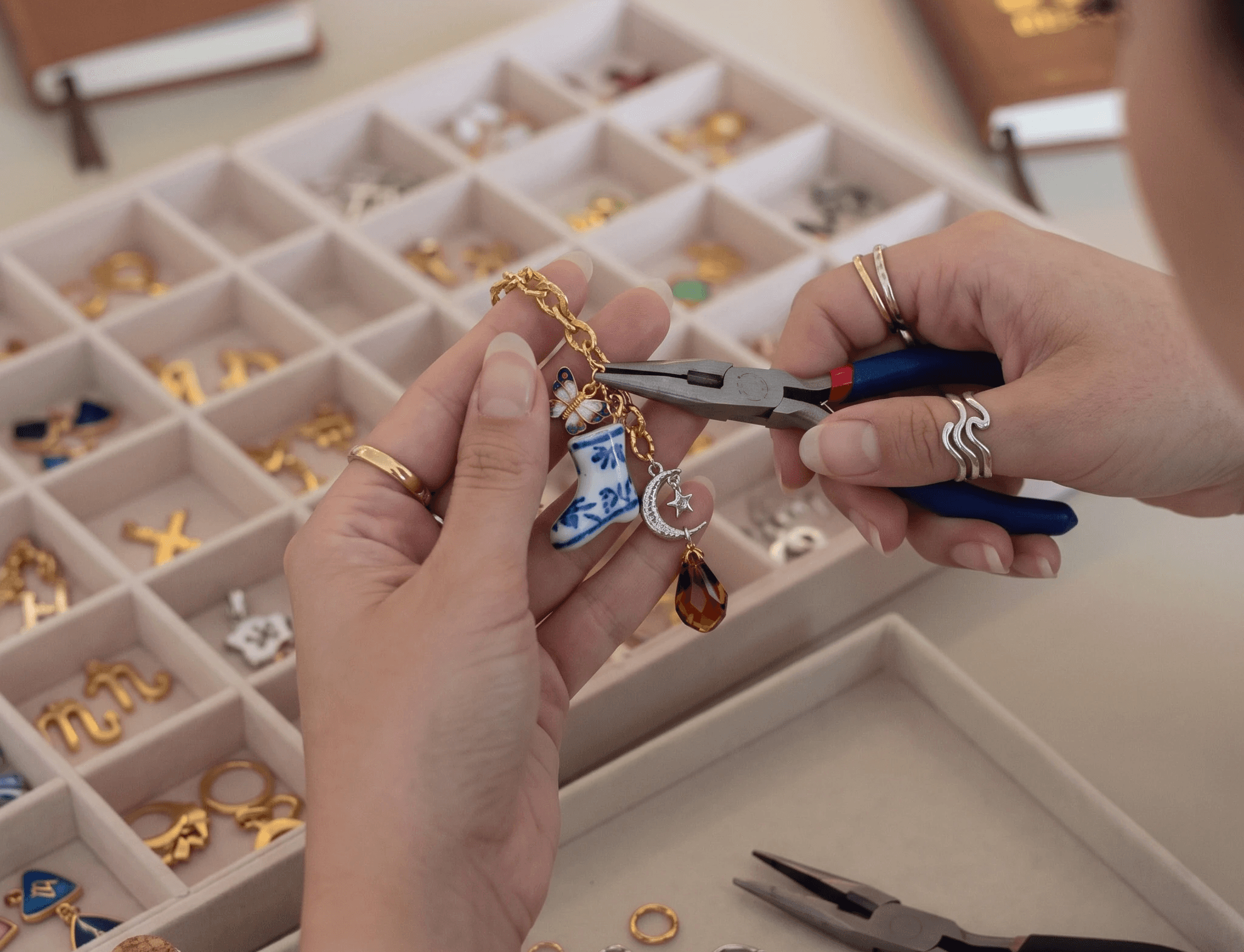 Person clasping charms onto keychain