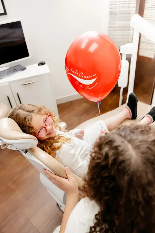 Girl in dental treatment chair with red balloon at ScarboroSmiles: : Best dentist in Scarborough, Ontario