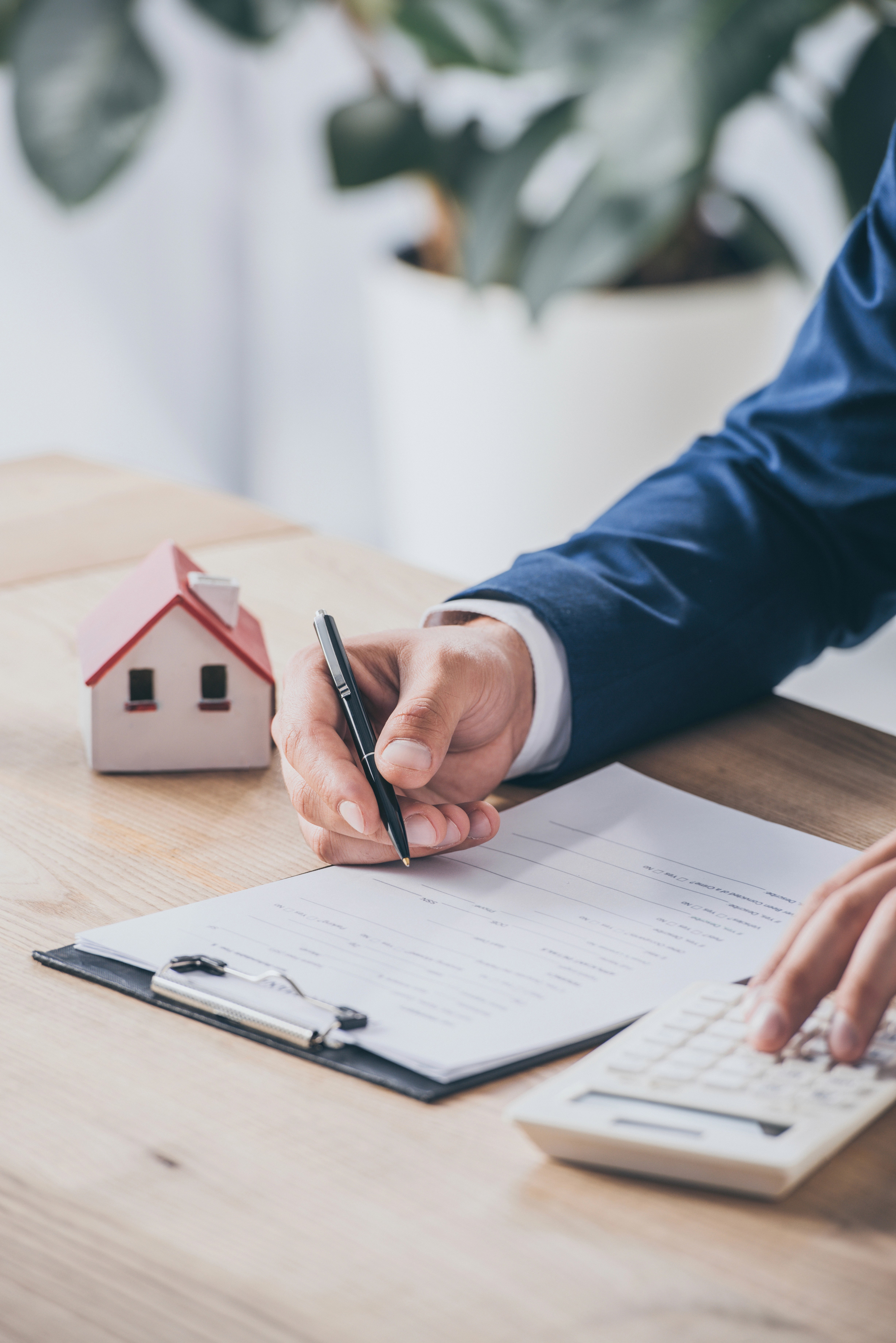 Signing residential property loan documents with calculator, representing SMSF residential lending
