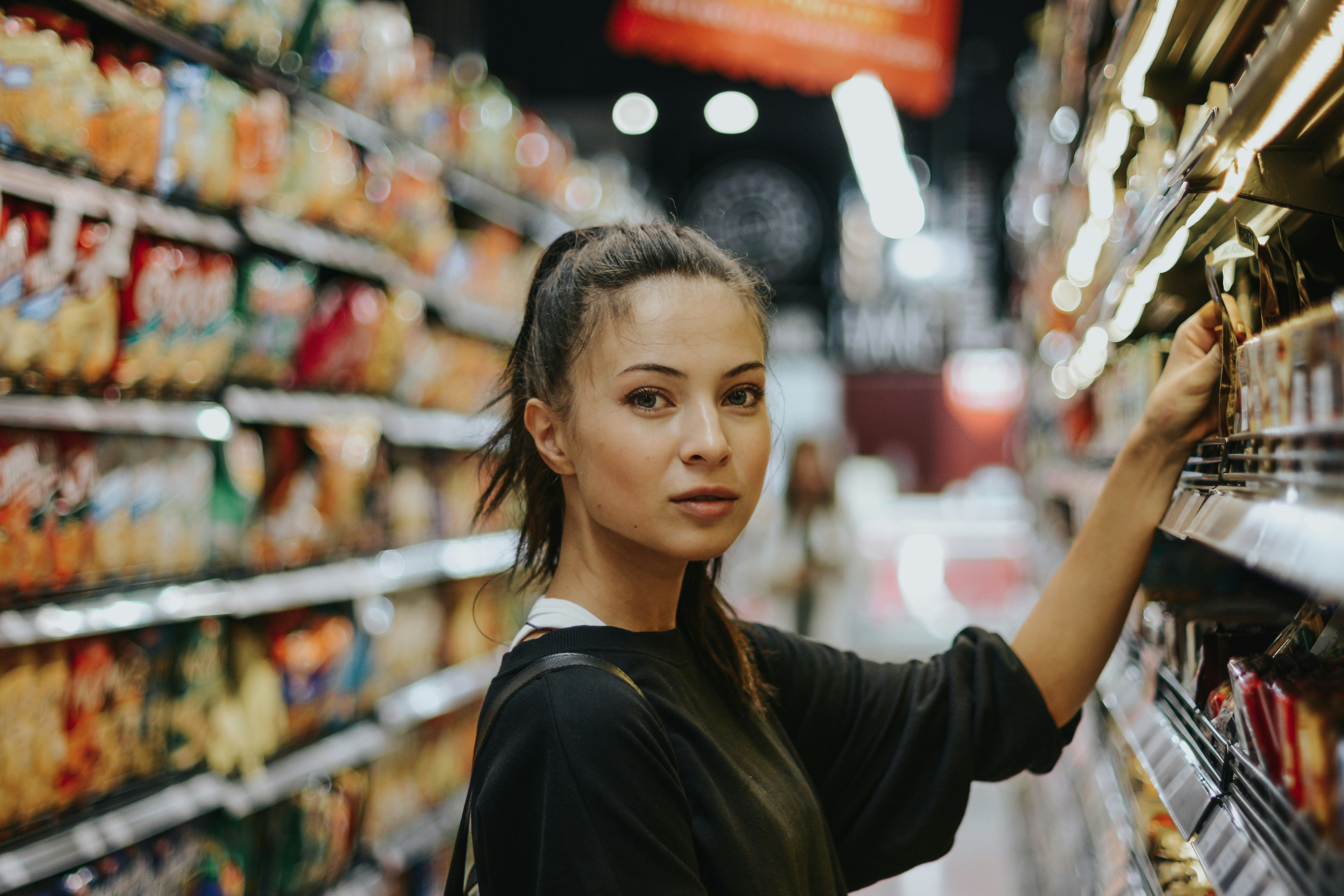 Women looking straight into the camera while choosing products in the supermarket