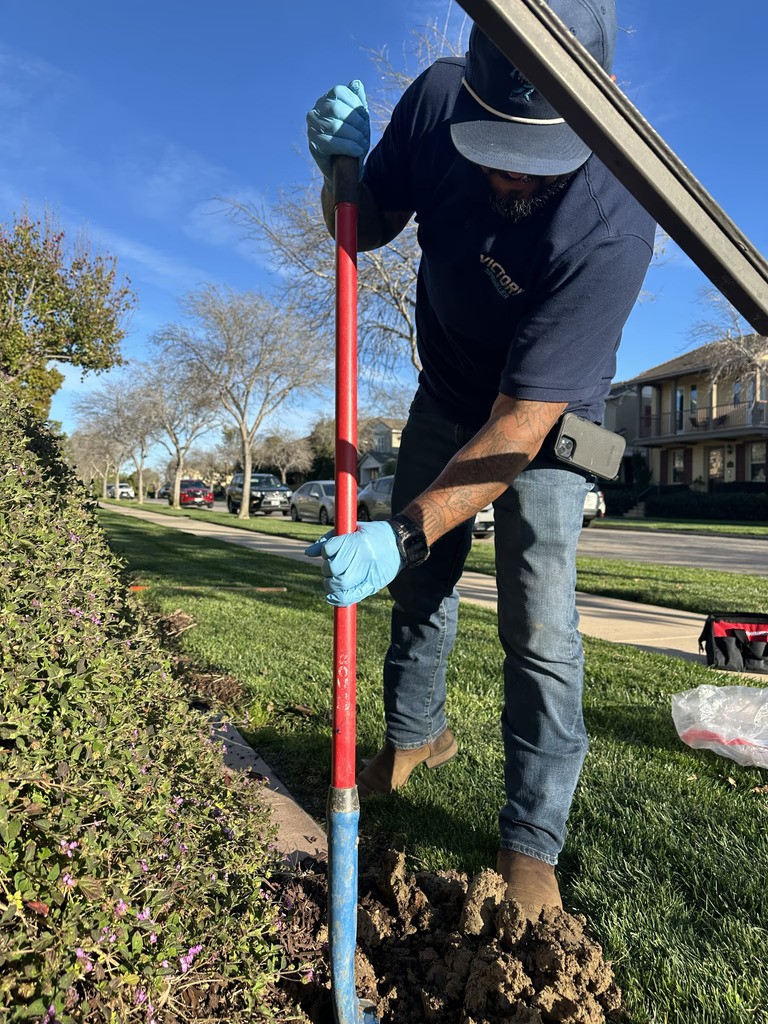 A professional irrigation technician carefully performing a sprinkler repair within a lawn, demonstrating the hands-on precision of our service process.