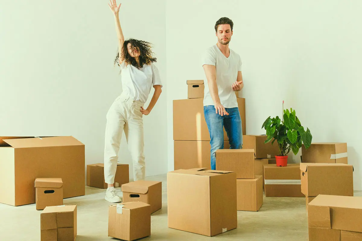 Couple dancing inside of a house with boxes.