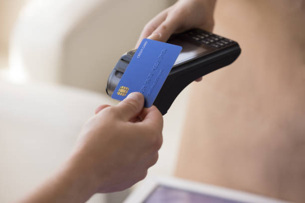 An individual tapping their card on an EFTPOS terminal.