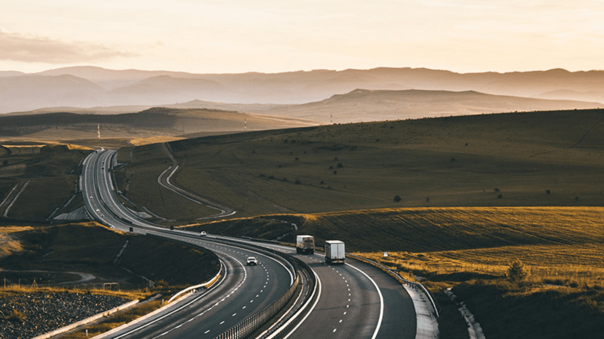 Wide shot of a highway undulating through hilly countryside