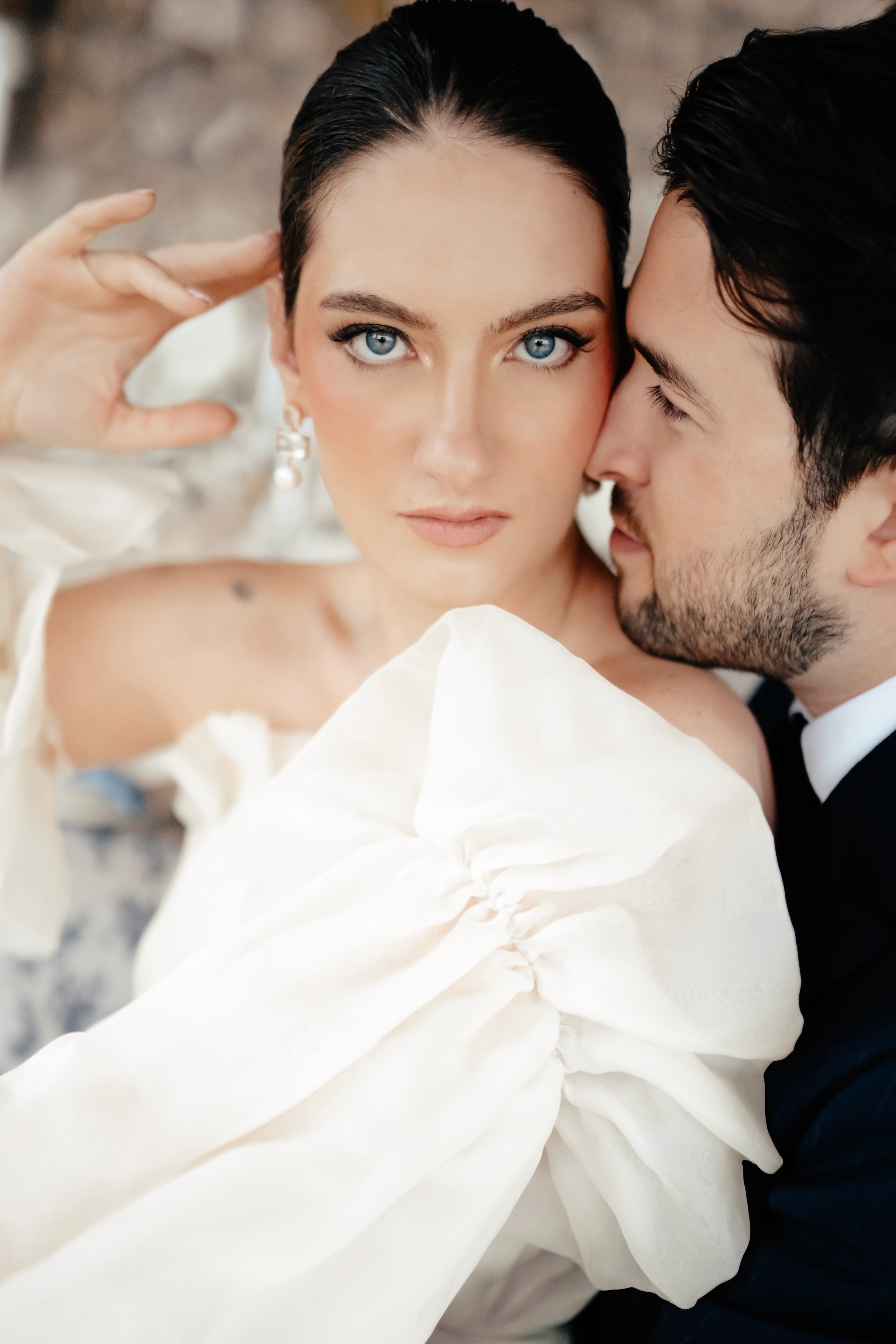 A bride in a lace wedding dress gently holds.