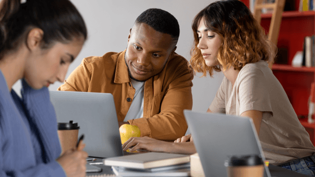 Photo of a guy and a lady looking seated on chairs looking into a laptop