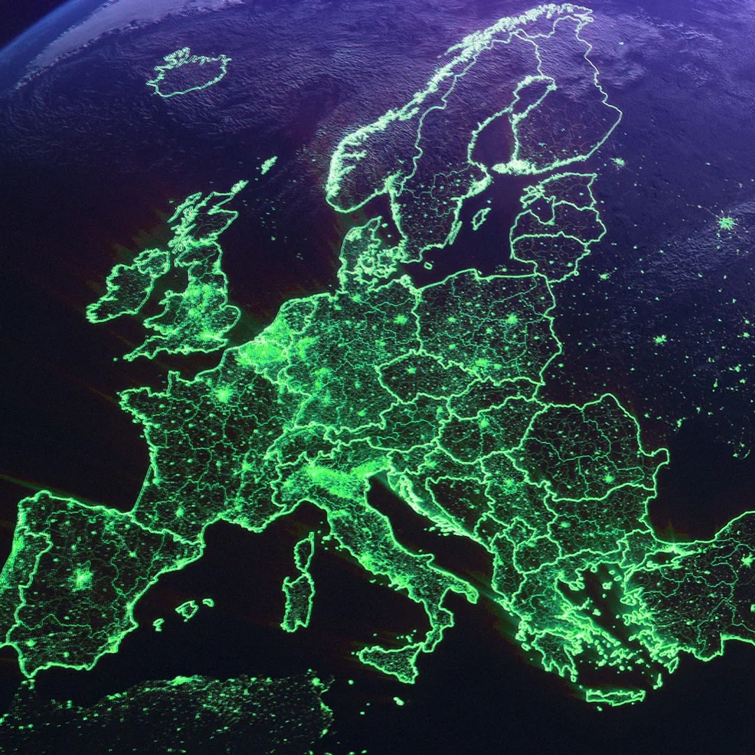 Satellite view of Europe at night with green glowing borders and city lights highlighting the continent's road and population density network.
