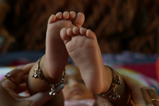 a close up of a baby's foot with a chain around it