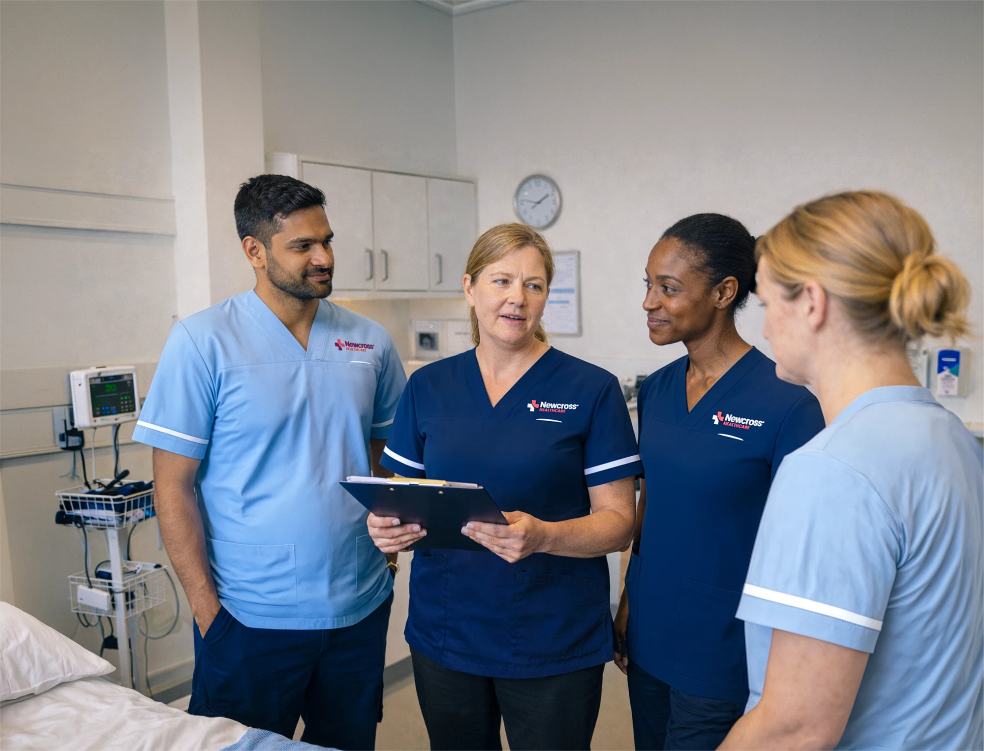Newcross Healthcare nurses and healthcare professionals discussing patient care in a modern private hospital room.