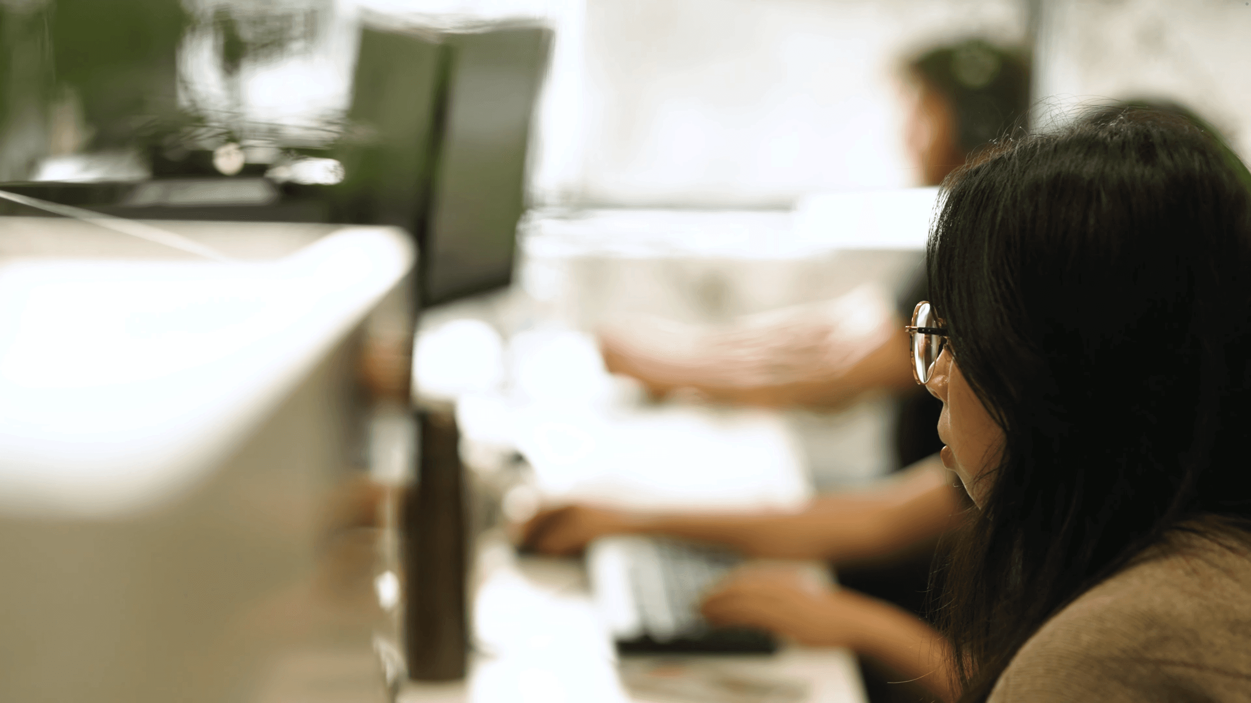 above the shoulder shot of a woman working at a desk