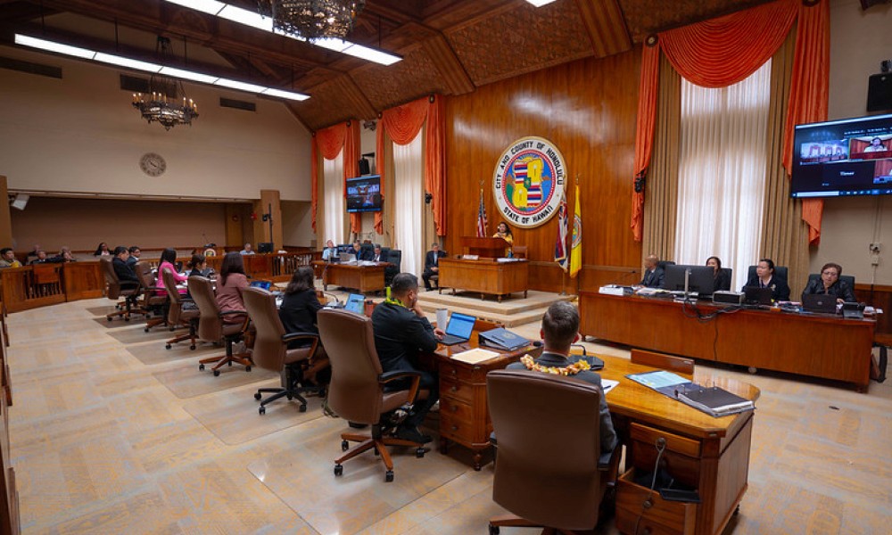 A photo of the council chamber during a full council meeting. All councilmembers are present at their seat with council chair at the podium. Header photo courtesy: Council Support Services