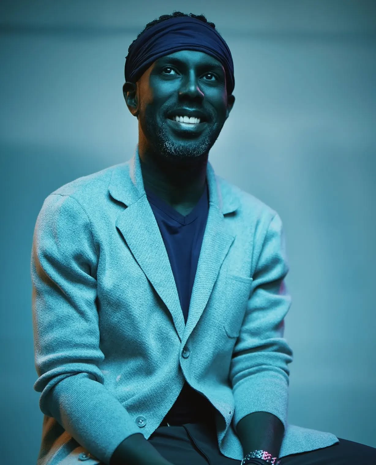 Black and white portrait of a smiling person with curly hair