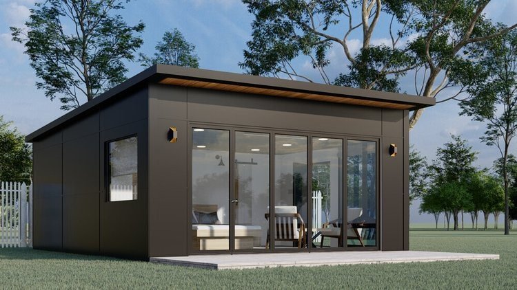 Modern modular unit with a dark exterior, large glass doors, and a wood-accented ceiling, set in a grassy outdoor space with surrounding trees.