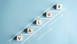 ive light wooden blocks spelling out the word "VALUE" are arranged diagonally on a light blue background, simulating steps on a ladder or upward incline. The blocks are placed on a drawn line with a series of upward arrows, symbolizing growth or increasing value.