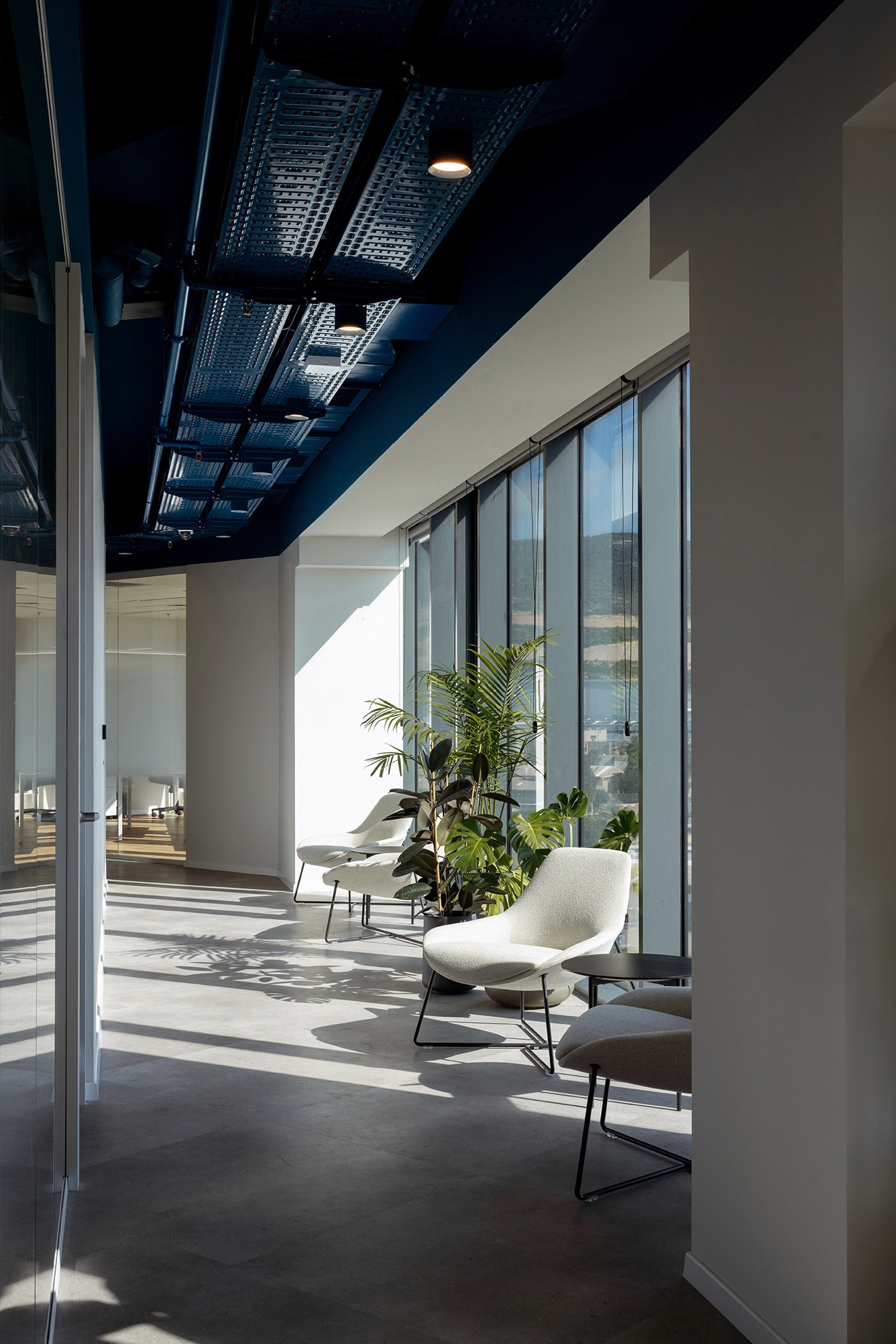 אזור התרגעות (Wellness Area) מול הים: ריהוט רך וכיסאות נוח הממוקמים בסמוך לחלונות המסך למנוחה במהלך יום העבודה