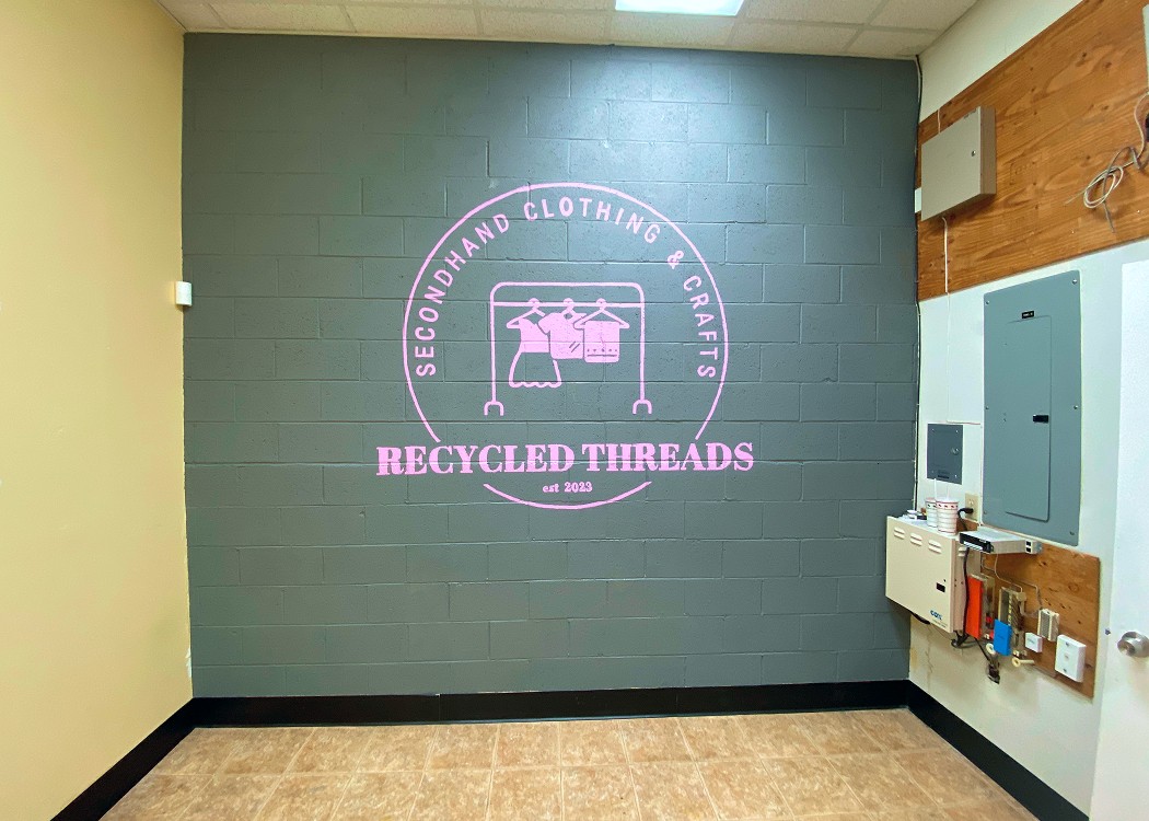 green accent wall with pink logo