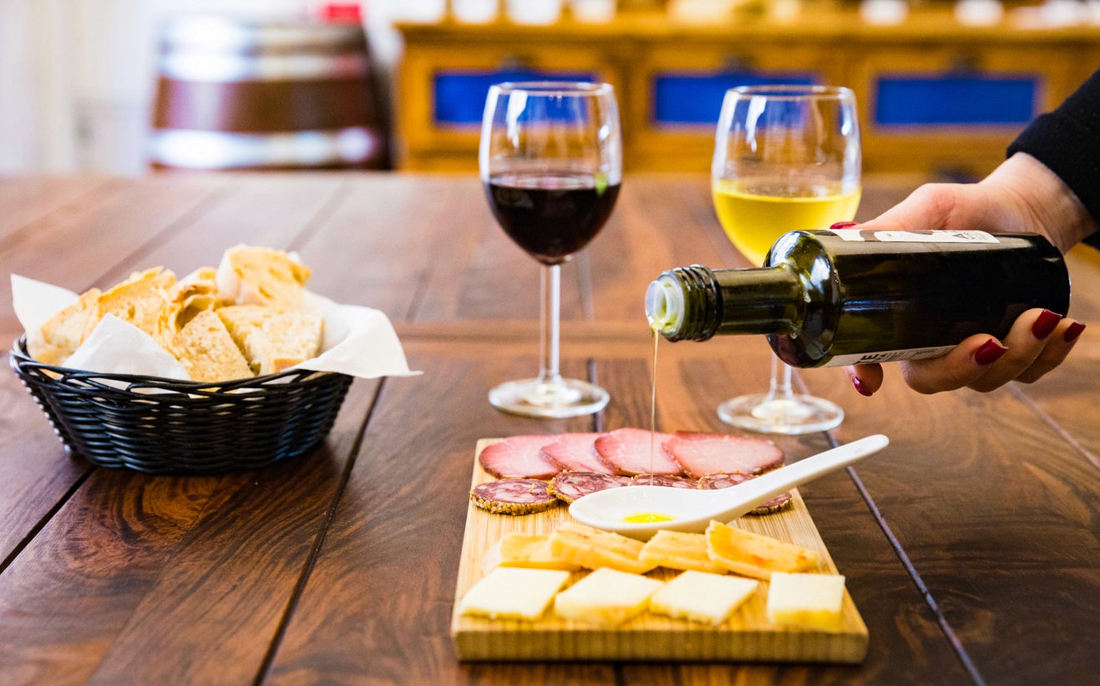 Olijfolie wordt over een kaas- en charcuteriebord met wijn in Lissabon gegoten.