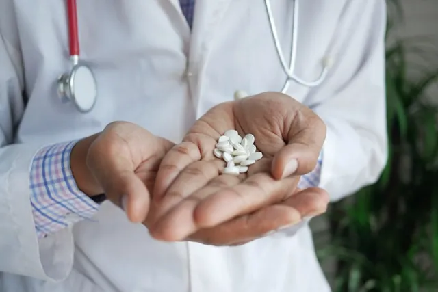 White aspirin tablers on human's hands