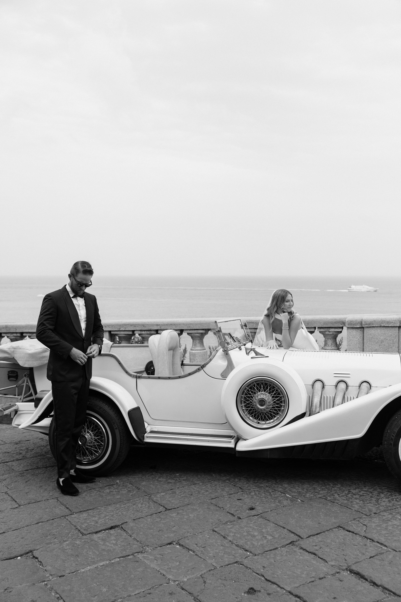     Wedding photographer South Florida captures a bride and groom beside a vintage car in an editorial destination wedding portrait.