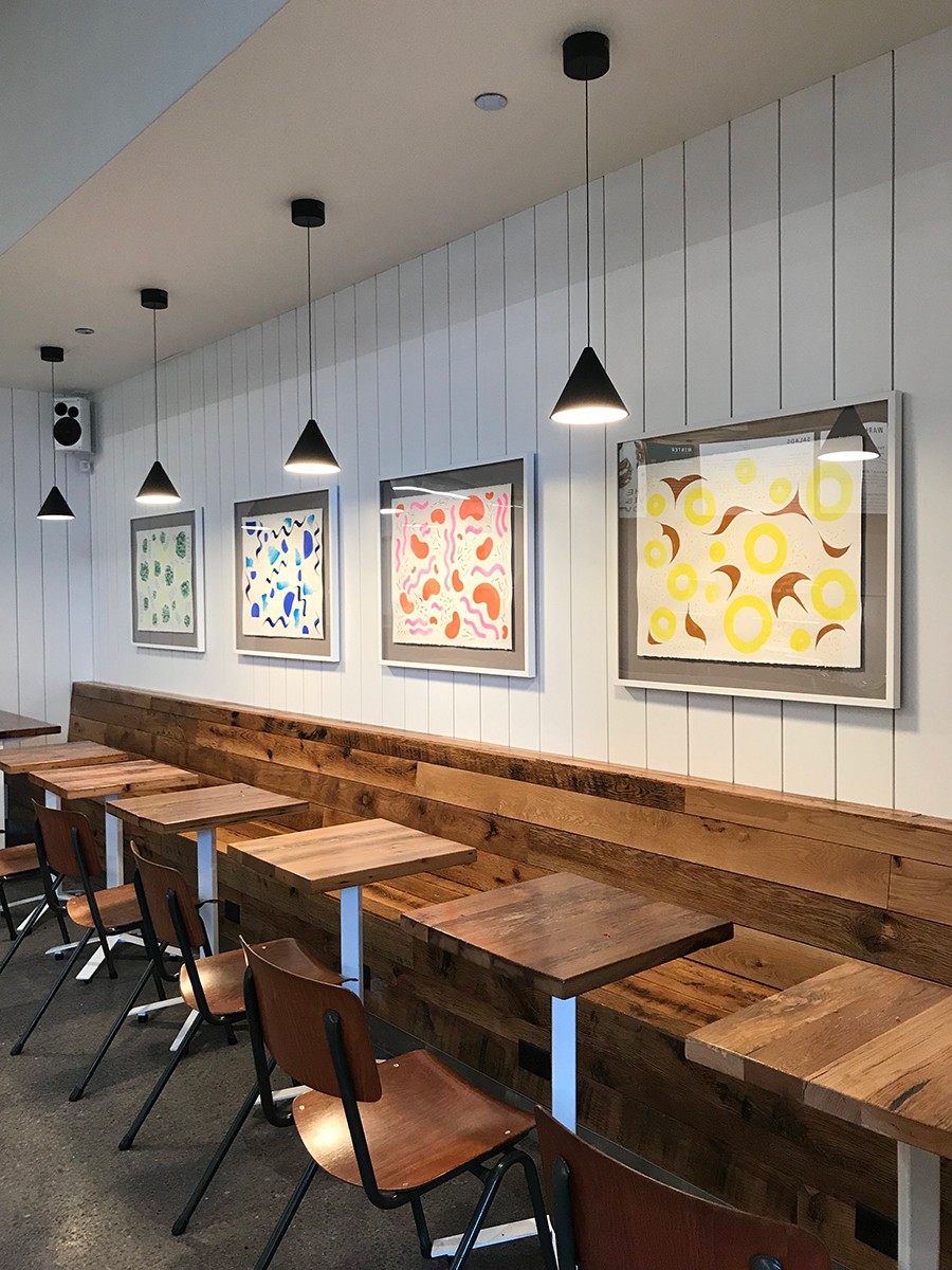 Four seasons Sweetgreen paintings hanging on the wall in the restaurant