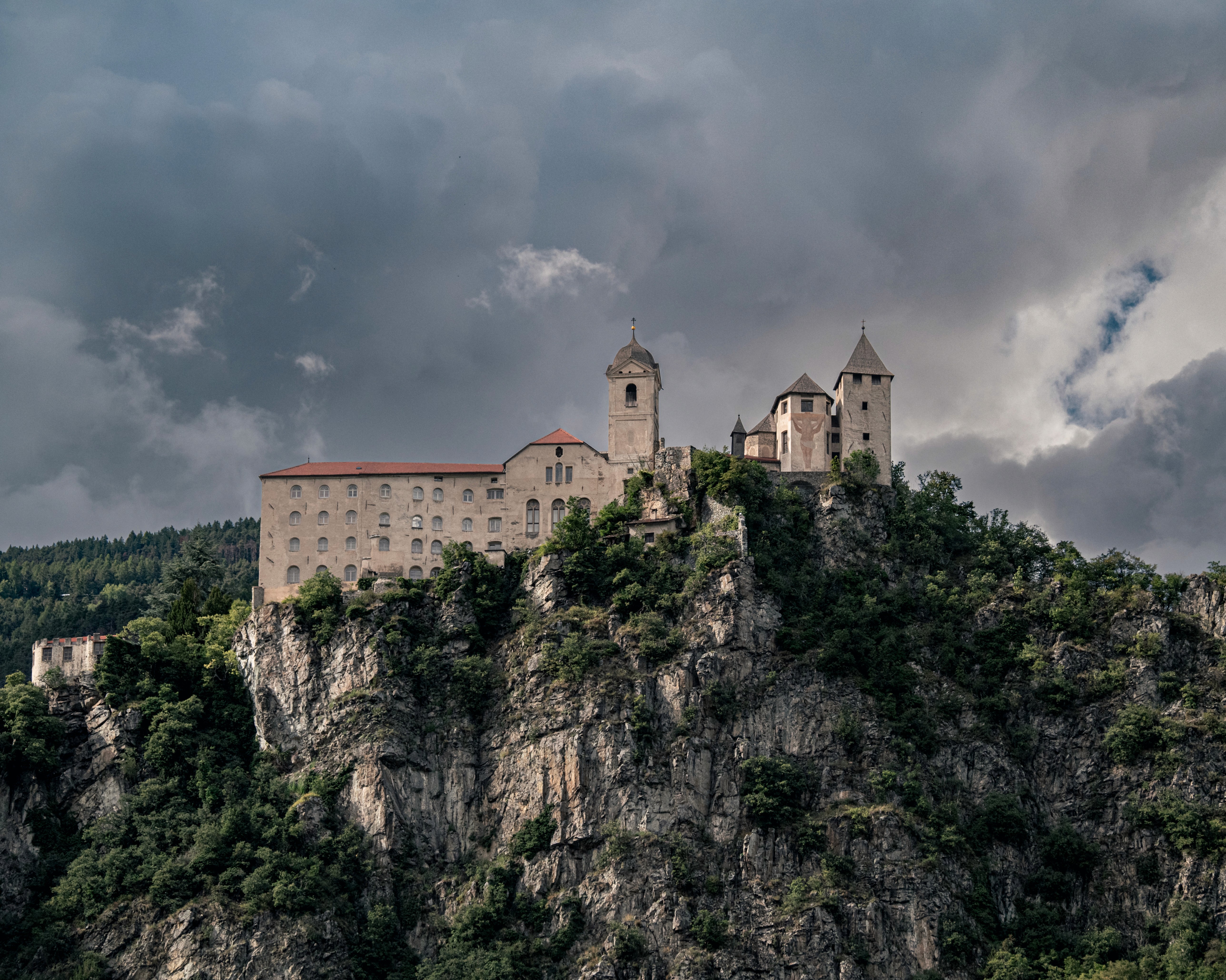 Historic stone castle set above a forested rock outcrop