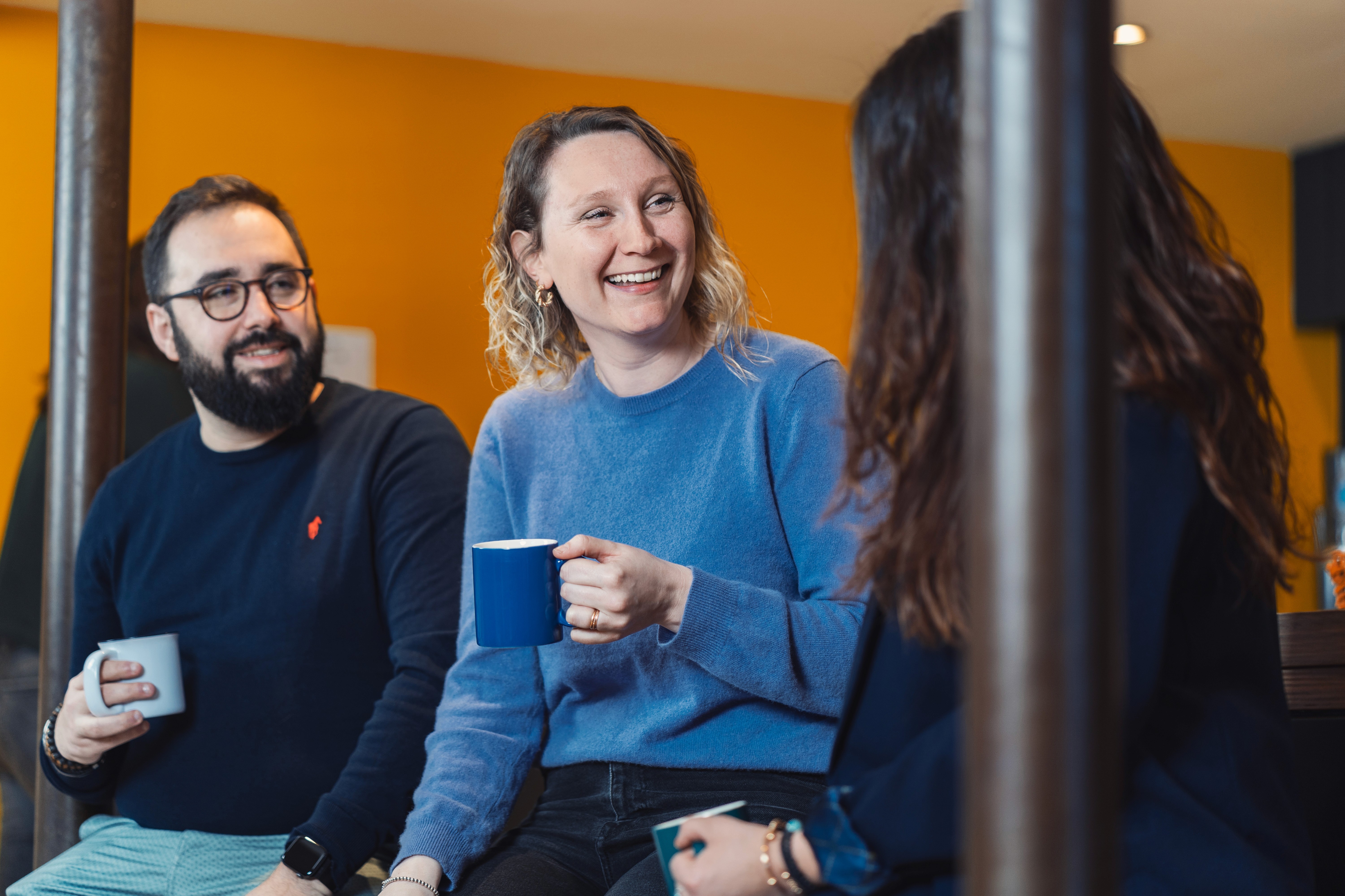 trois personnes en train de discuter et boire le café