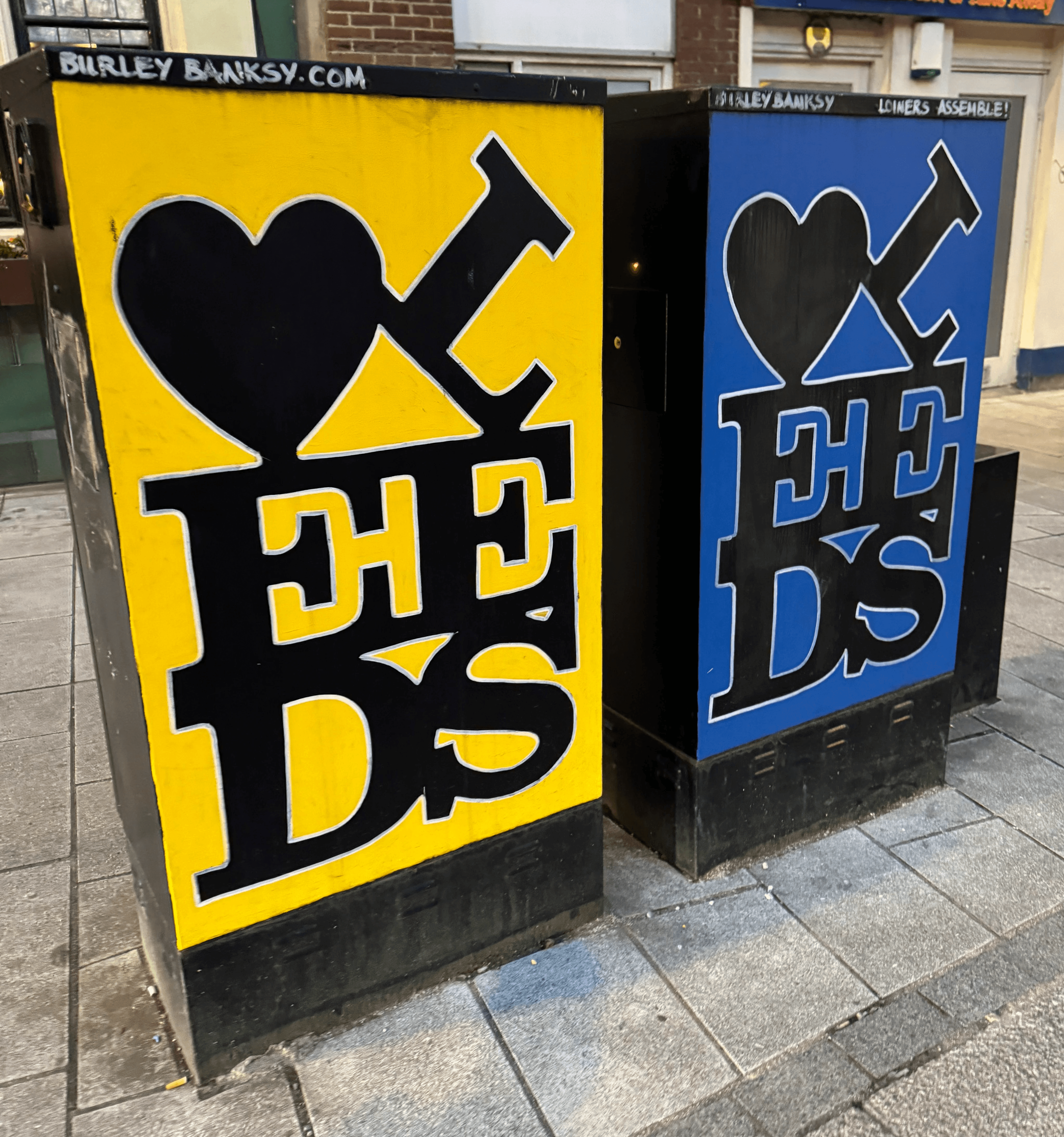 Leed city centre graffiti electrical boxes in street in yellow and blue