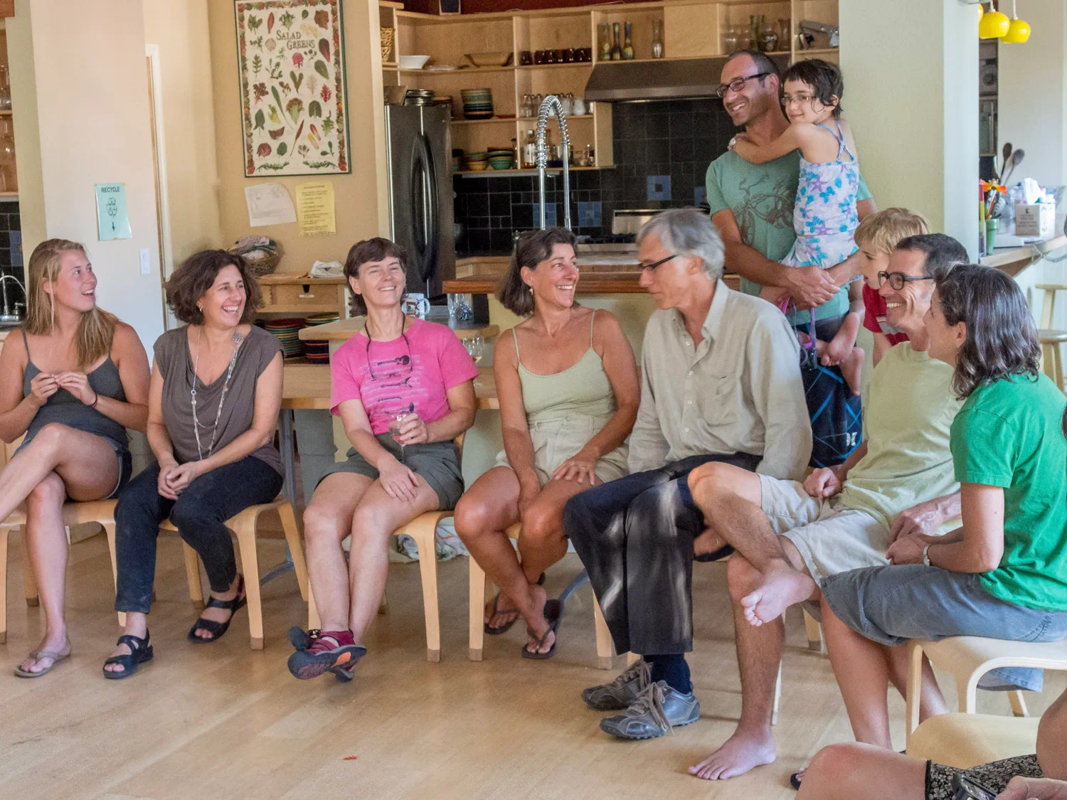 Community members gathered together indoors in conversation during a cohousing meeting.