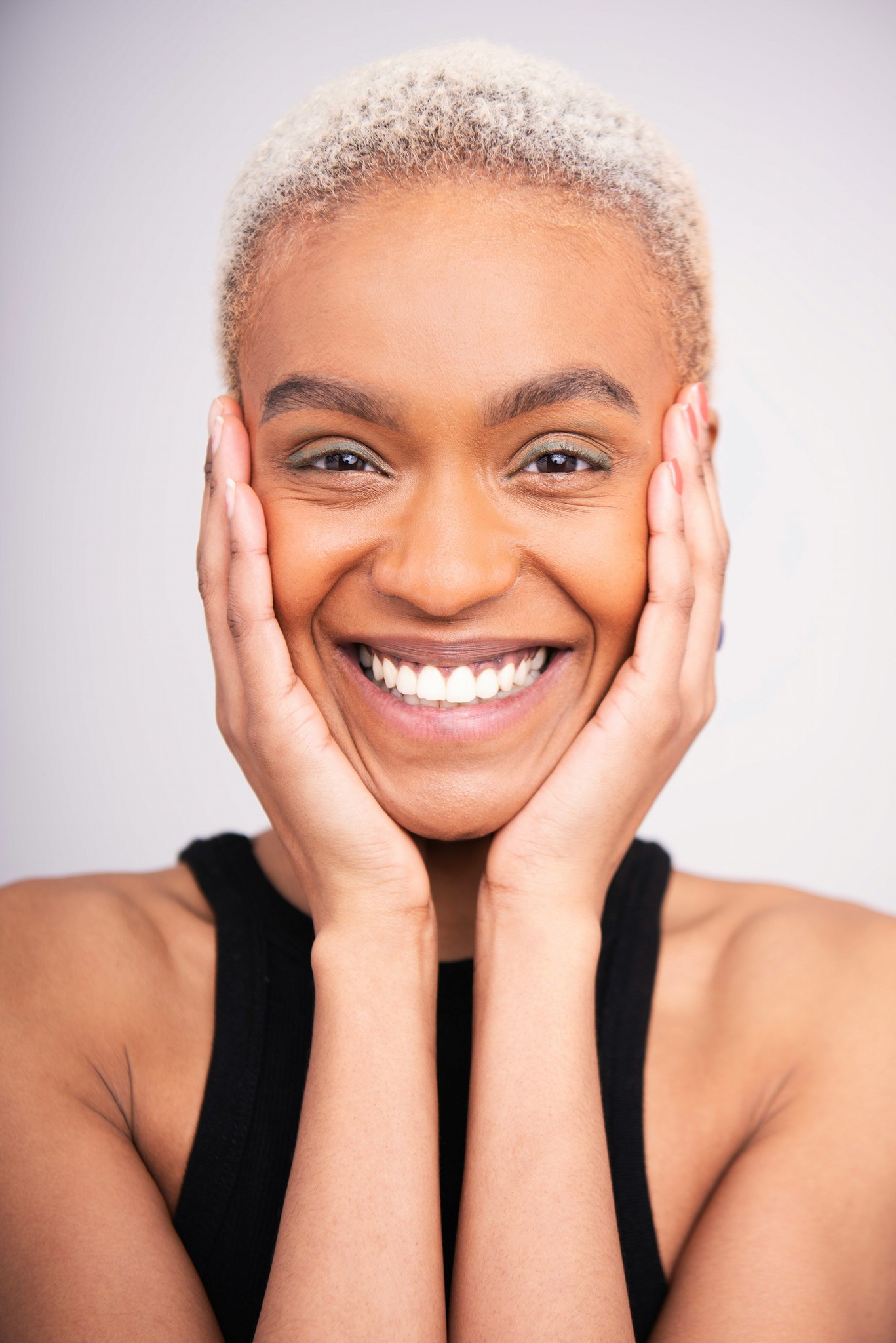 A smiling woman cupping her face in her hands