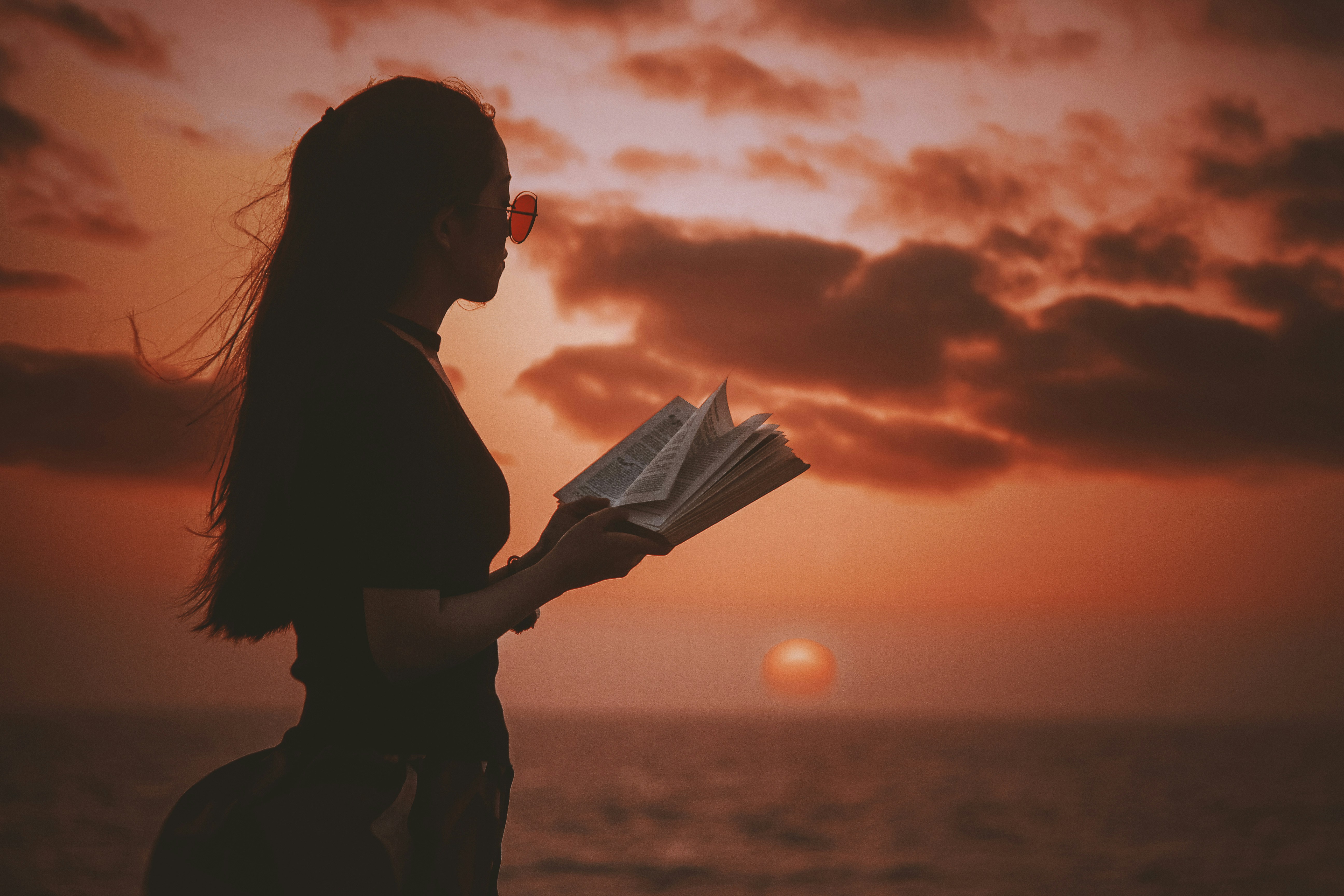woman holding a book by the sea - medical school studying tips