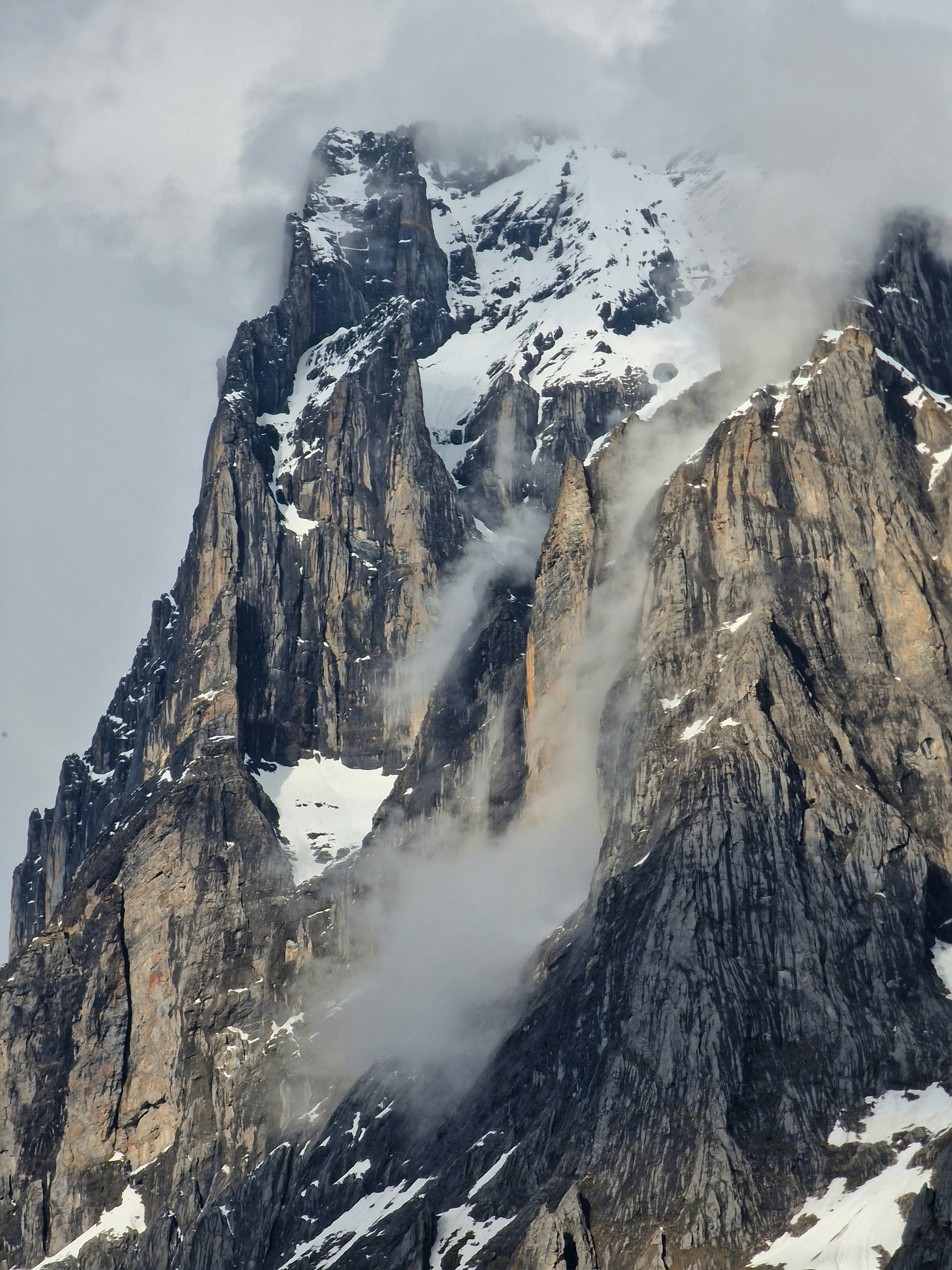 a very tall mountain covered in snow and clouds