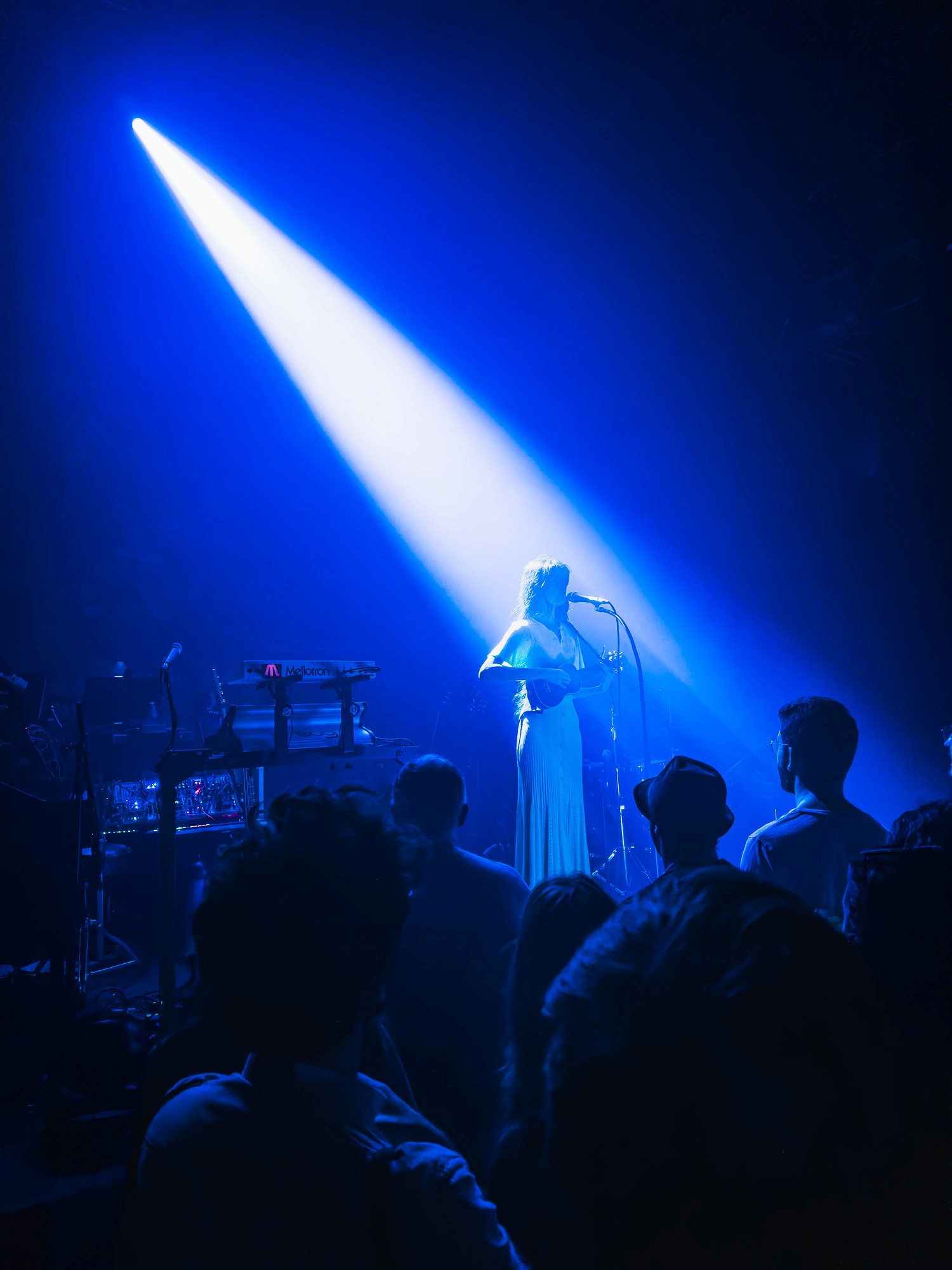 Chanteuse au micro dans un rayon de lumière bleue, Café de la Danse