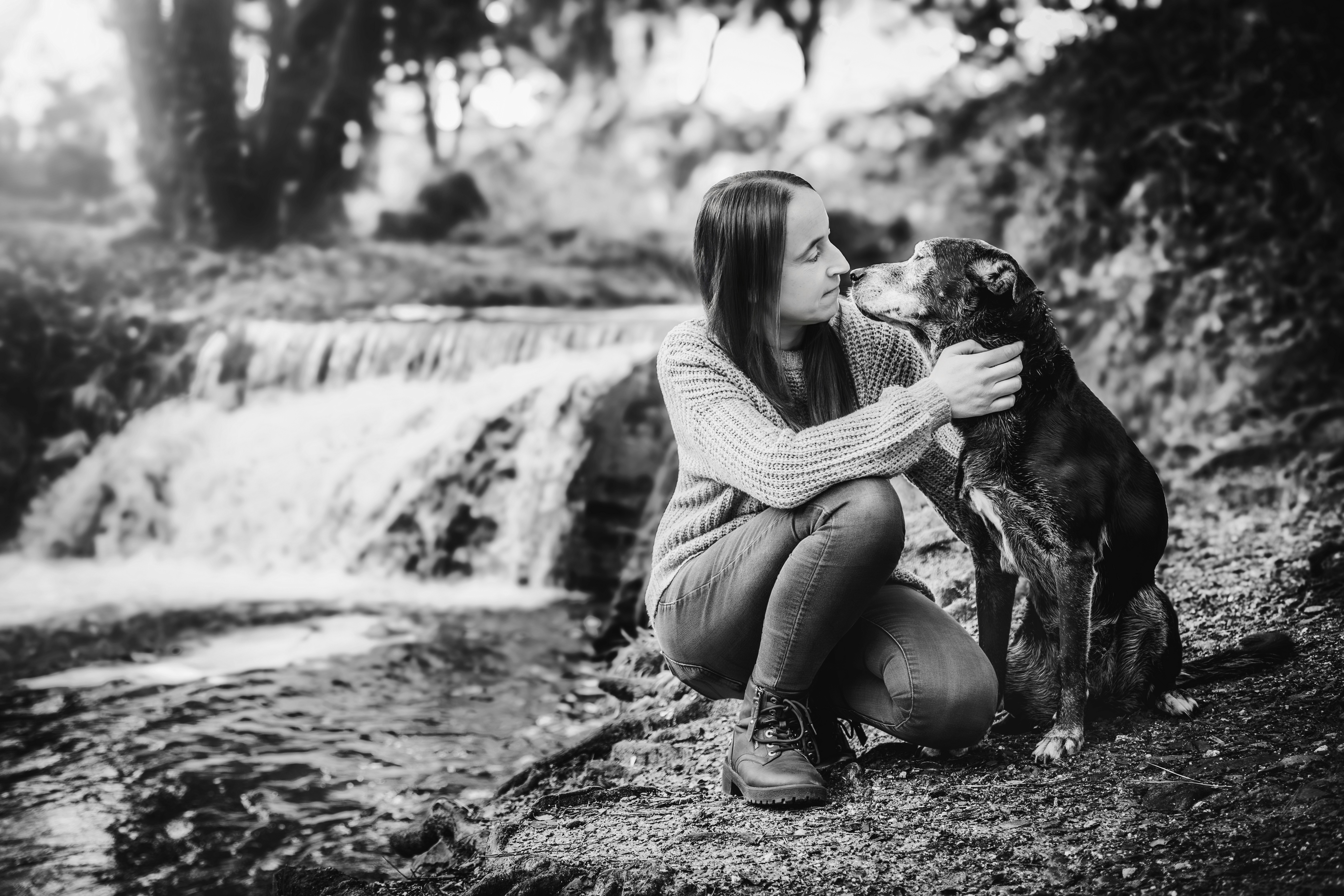 Perro y su dueña al lado de una cascada
