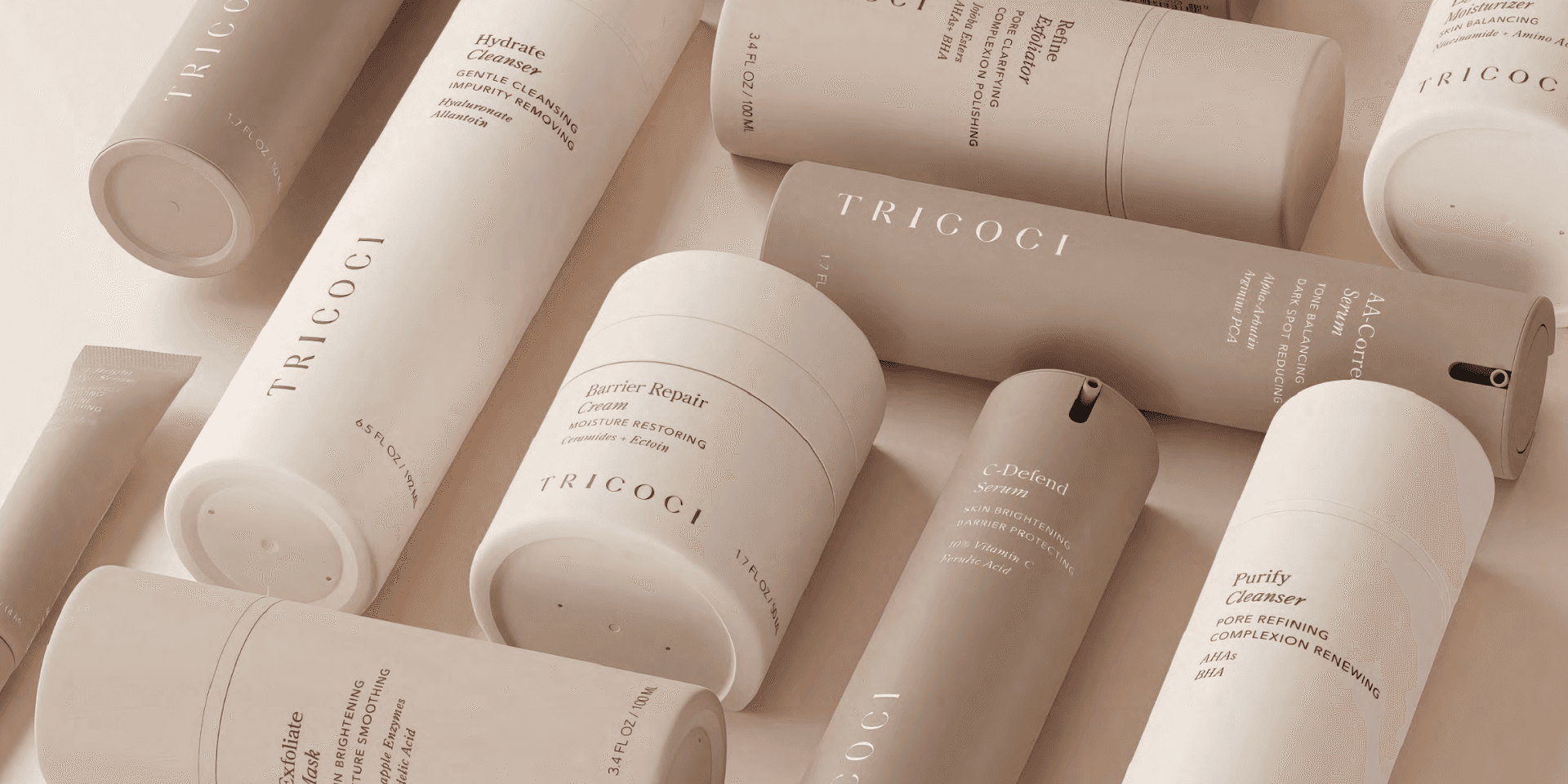 Markenwelt Tricoci – Skincare-Linie in Sand- und Beigetönen, minimalistische Tuben, Tiegel und Flakons mit feiner Typografie.