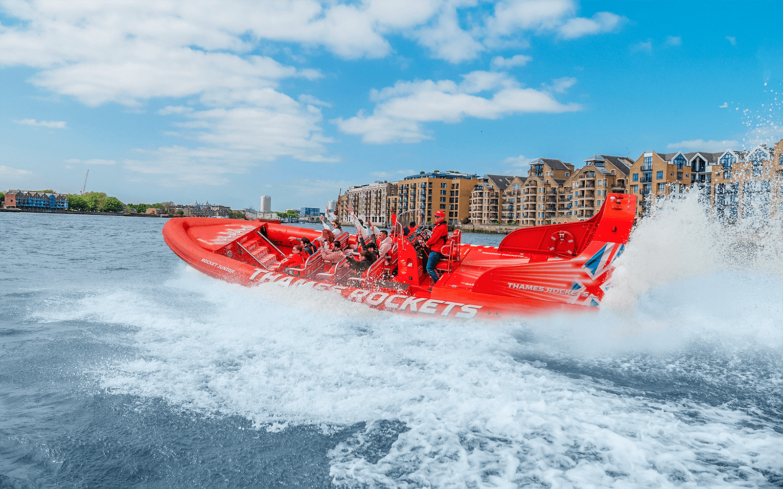 Speed boat on the Thames River with passengers enjoying the ride, London.