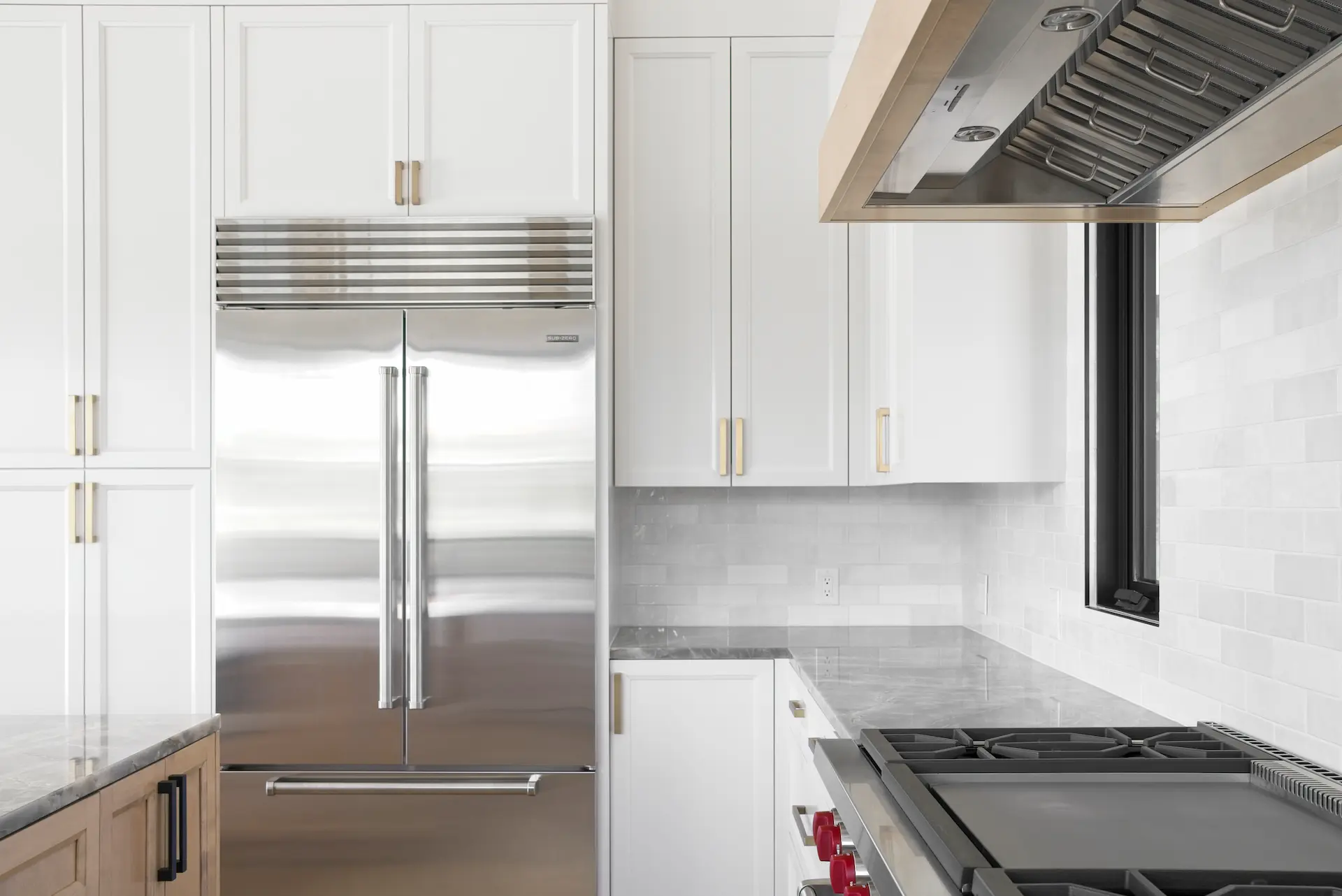Close-up in the kitchen facing the fridge, offering a view over the range and durable quartzite countertop, demonstrating the thoughtful layout in the Dana Point Full Remodel. Photo by Todd Huge.