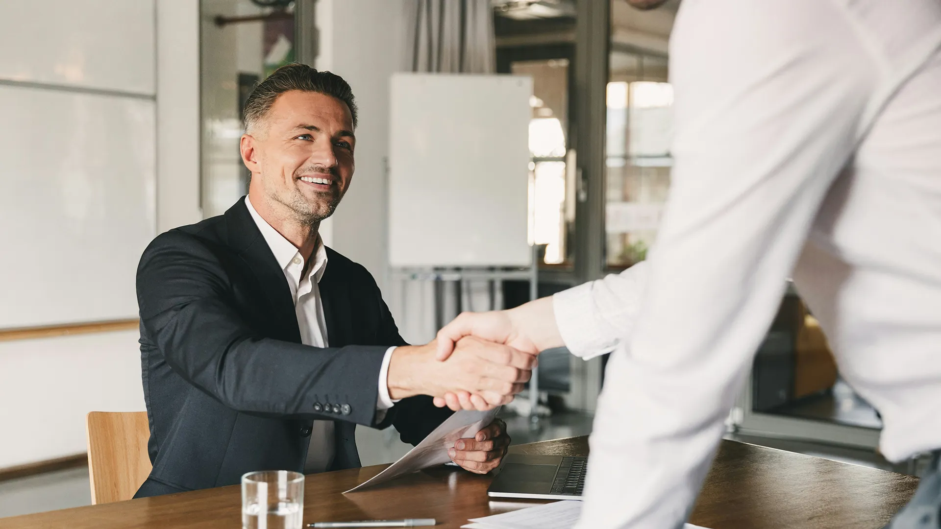 Shaking hands over successful deal in office showroom