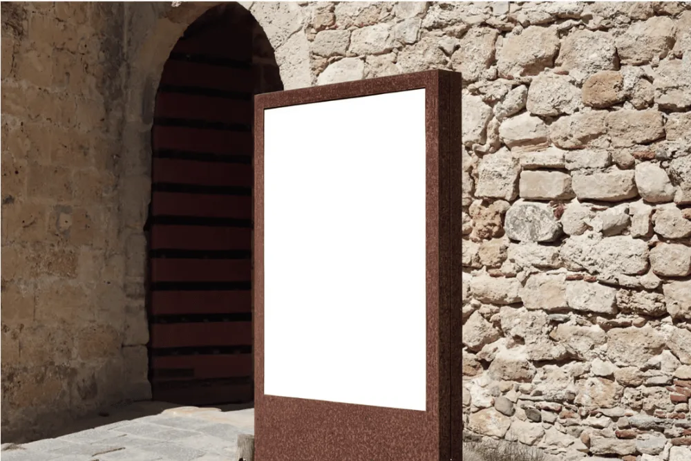 Outdoor directional sign mockup displayed against a rustic stone wall. The sign features a vertical rectangular frame with a weathered brown finish and a beige background.