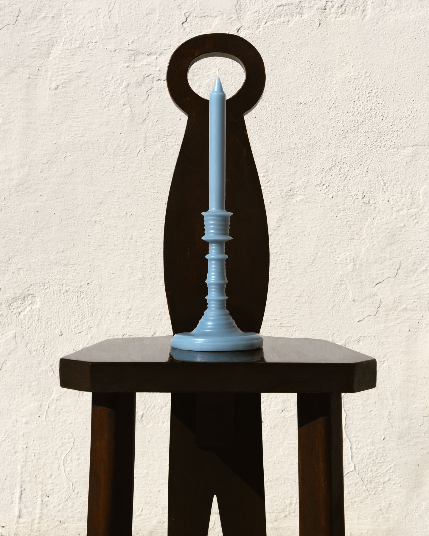 Cypress Balls LOEWE Wax Scented Candleholder styled on a wooden side table against a whitewashed wall.