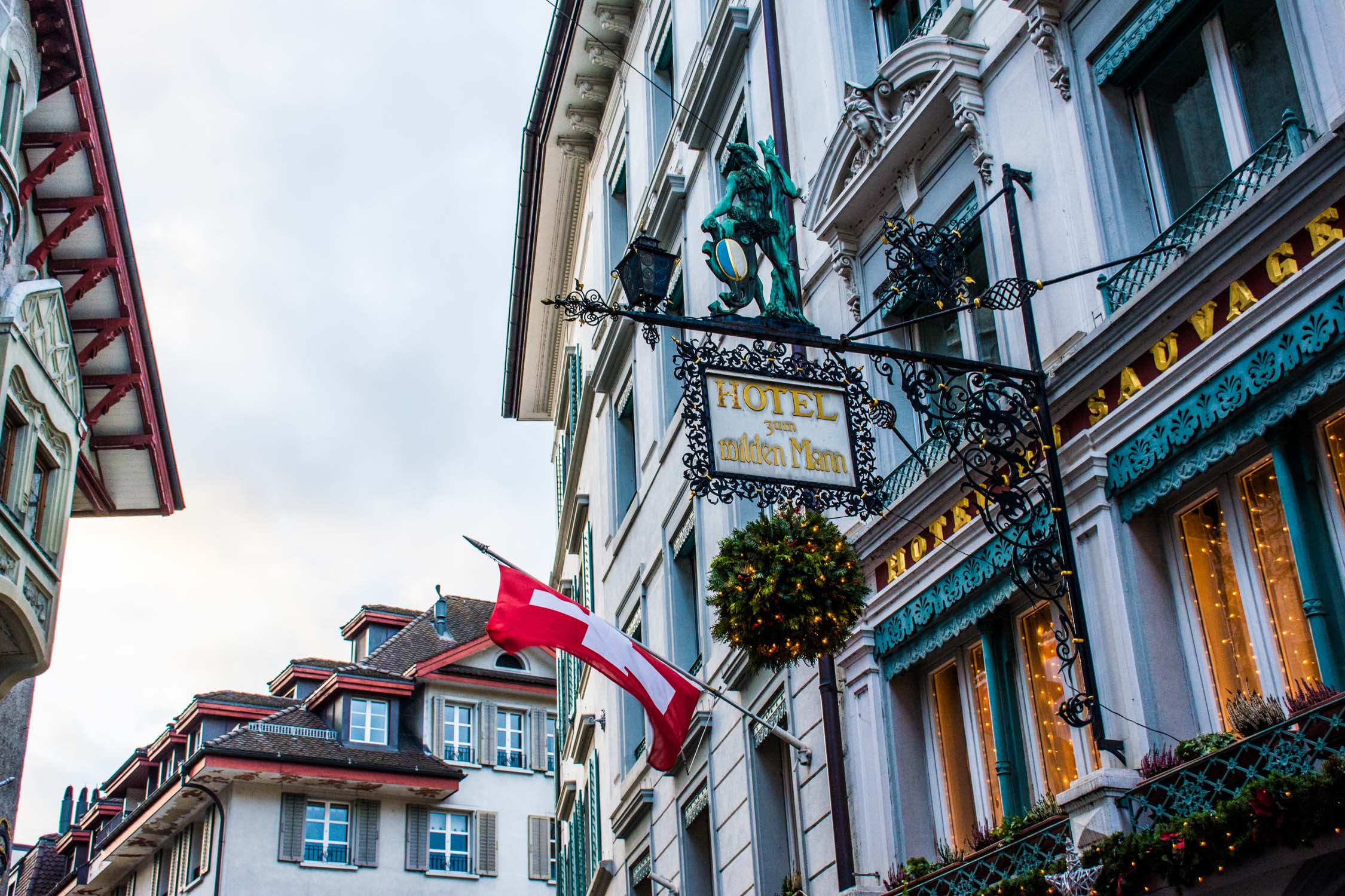 A turquoise and white Victorian-style building features a "Le Grand Brasserie" sign and a Canadian flag in front.