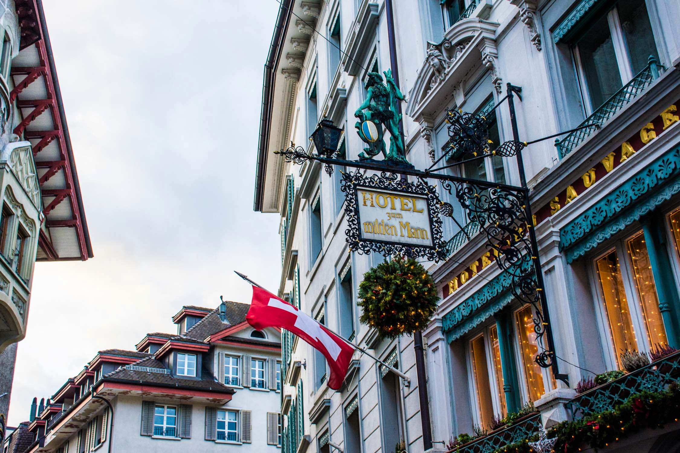 A turquoise and white Victorian-style building features a "Le Grand Brasserie" sign and a Canadian flag in front.