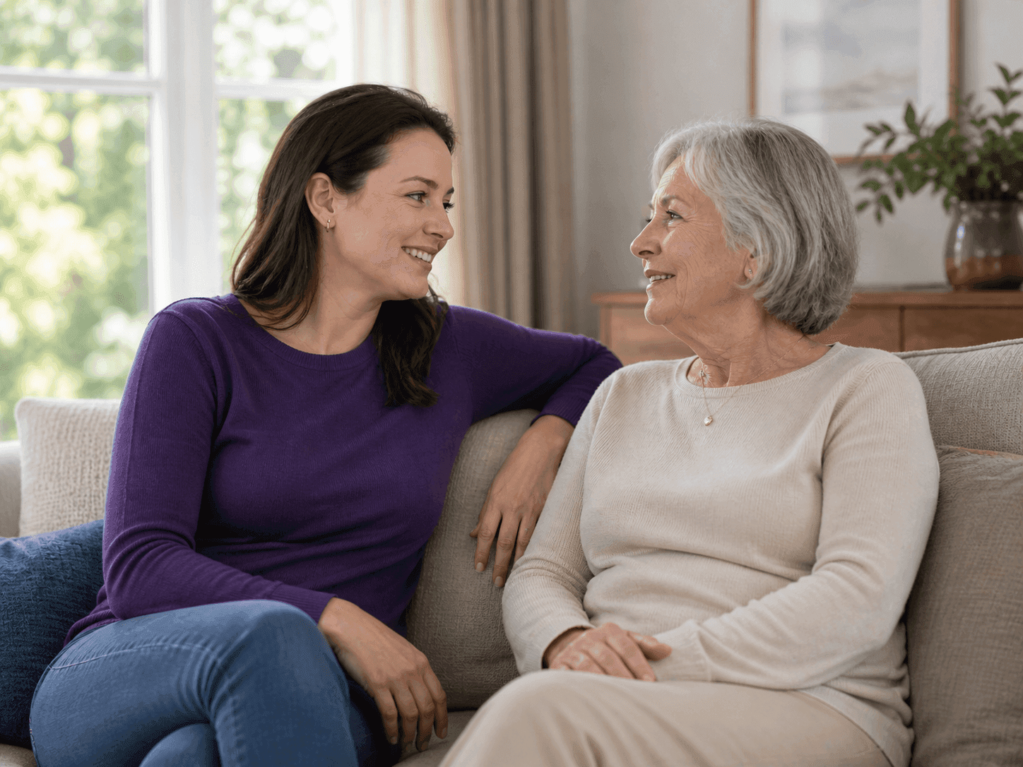 Professional caregiver listening attentively to an elderly client at home