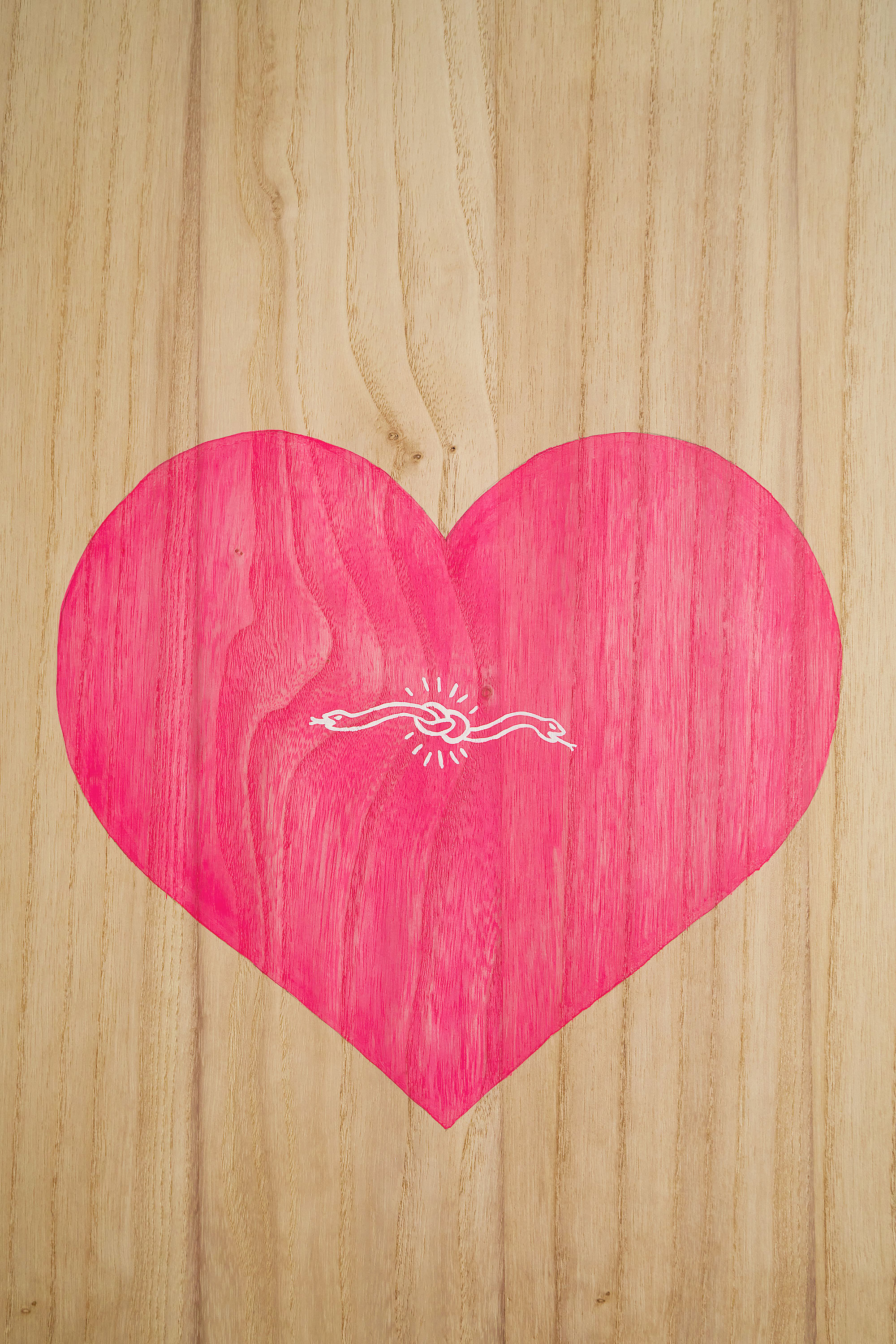 Hand painted heart artwork on a wooden surfboard