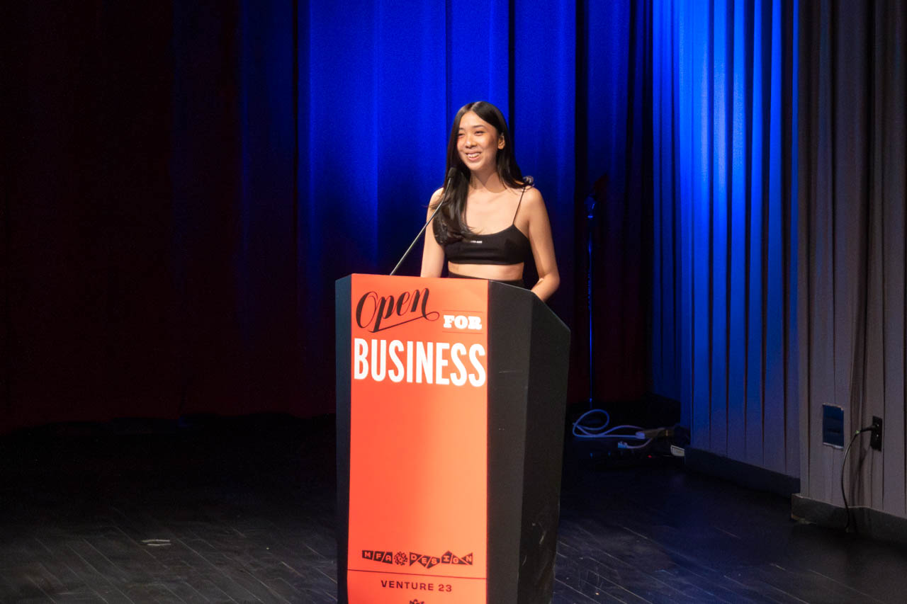 woman standing at a podium delivering a presentation