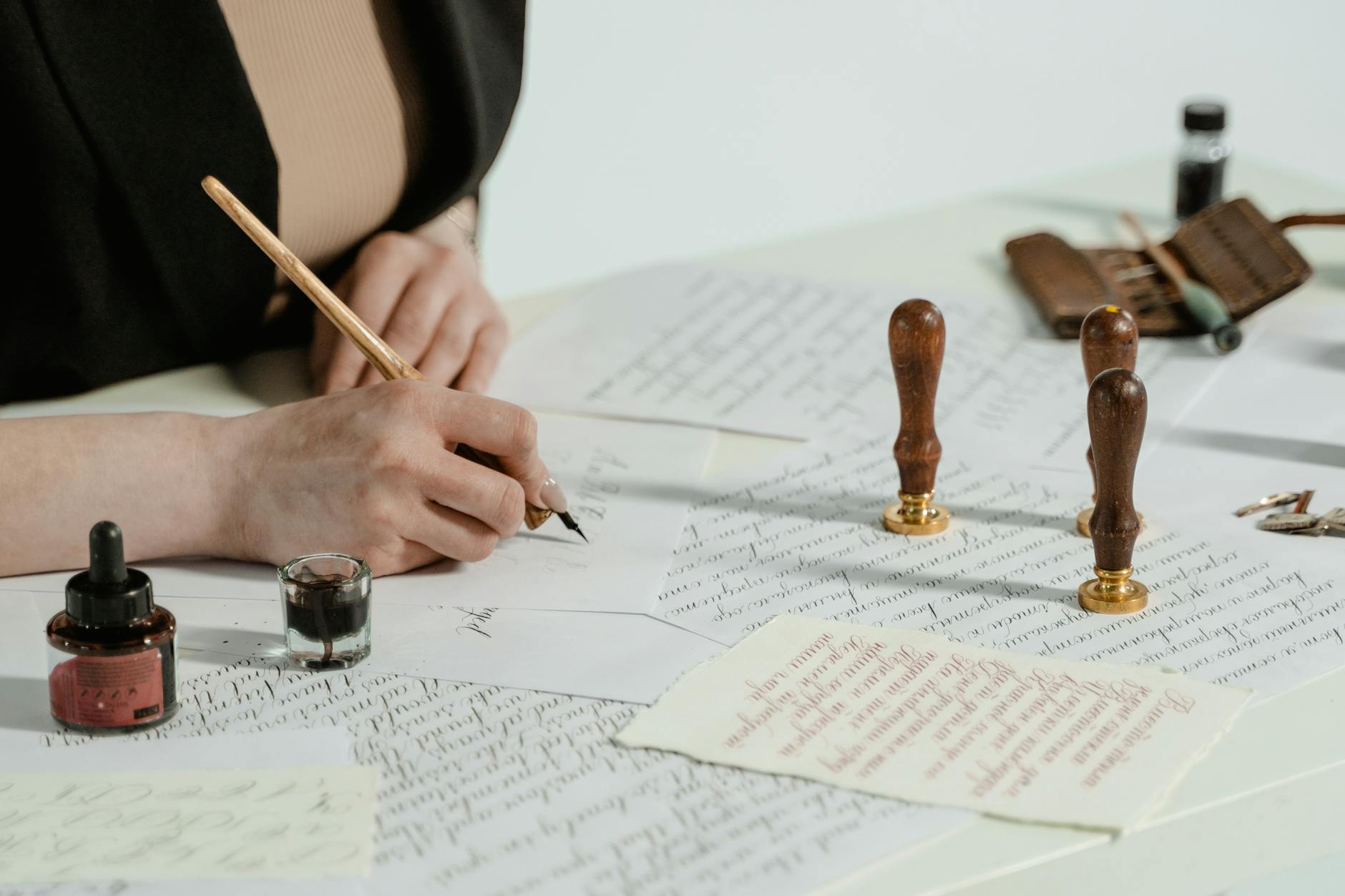 Close-up of a person's hands typing on a laptop next to a legal notepad and a cup of coffee.